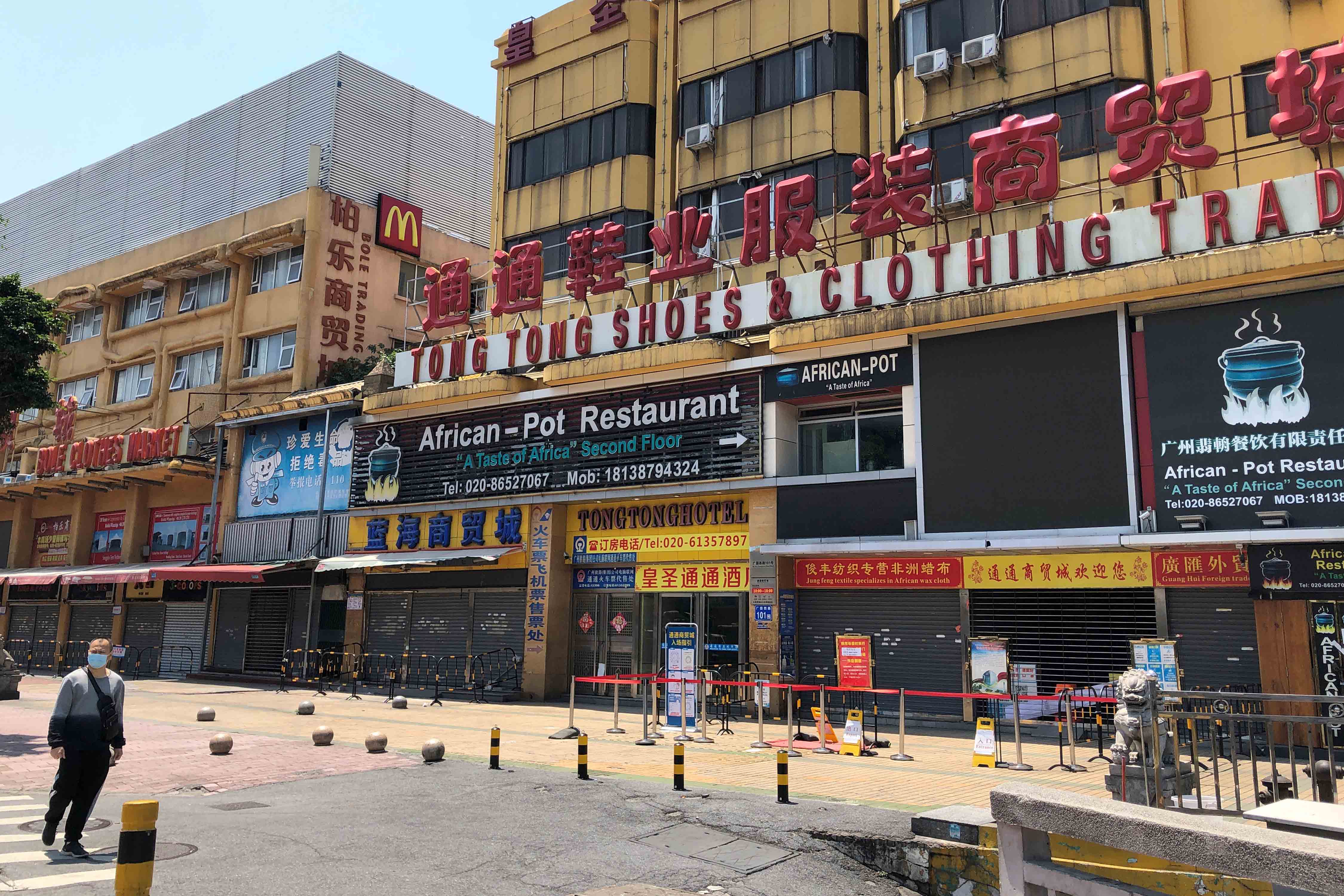 Un homme passe devant un restaurant africain fermé dans le quartier de Sanyuanli à Guangzhou (province du Guangdong), dans le sud-est de la Chine, le 13 avril 2020. Les risques liés au Covid-19 ont conduit à des mesures de confinement, mais aussi à des incidents de racisme contre la population africaine, dans diverses villes chinoises. © 2020 Reuters / David Kirton