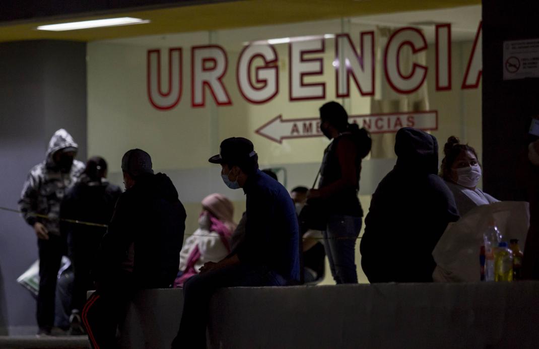 People were protective masks waiting outside an emergency room.