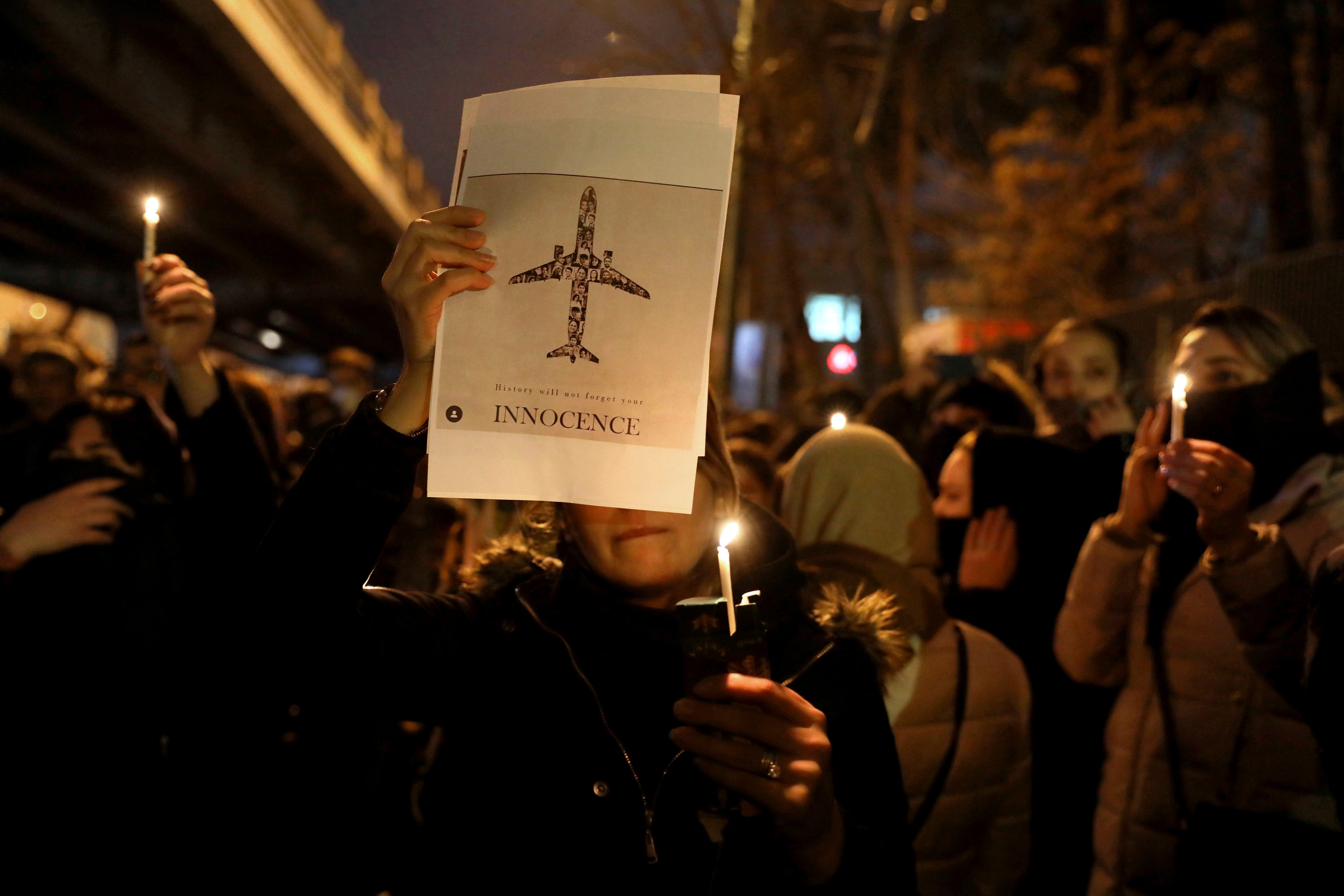 In this January 11, 2020, people gather for a candlelight vigil to remember the victims of the Ukraine plane crash at the gate of Amir Kabir University in Tehran, Iran.