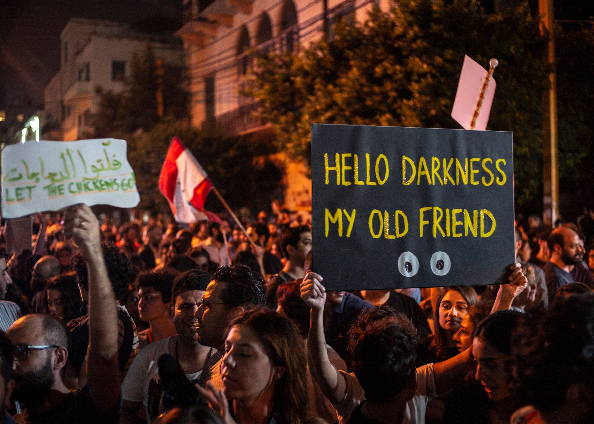 متظاهر يحمل لافتة تقول "مرحبا بالظلام، صديقي القديم"، أمام مبنى شركة "كهرباء لبنان" خلال مظاهرة ضد الحكومة والفساد، في بيروت، لبنان، 7 نوفمبر/تشرين الثاني 2019. © 2019 رفاييل يعقوب زاده/أباكا/سيبا عبر أسوشيد برس