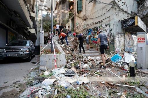 أشخاص يرفعون الركام إثر انفجار هائل في بيروت، لبنان، الأربعاء 5 أغسطس/آب 2020. هزت انفجارات ضخمة وسط بيروت الثلاثاء، فسوّت بالأرض معظم أجزاء المرفأ، وألحقت الضرر بالمباني، ونسفت النوافذ والأبواب بينما ارتفعت غيمة دخان عملاقة على شكل حبة فطر. قال شهود إن العديد من الناس جرحوا جراء الزجاج والركام المتطاير. 