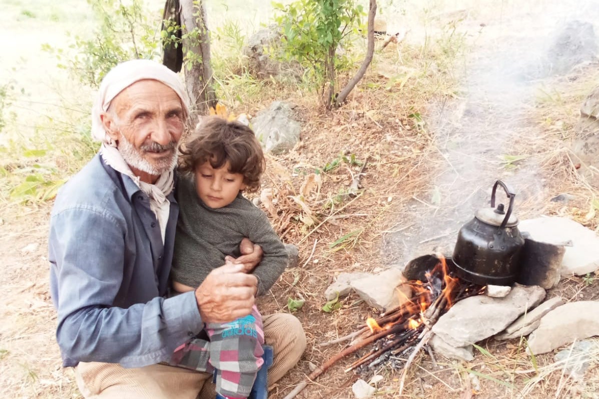 Servet Turgut, askeri gözaltındayken meydana gelen yaralanmalar sonucu 30 Eylül'de öldü. Fotoğrafta, torunu ile birlikte köyde bulunuyor.