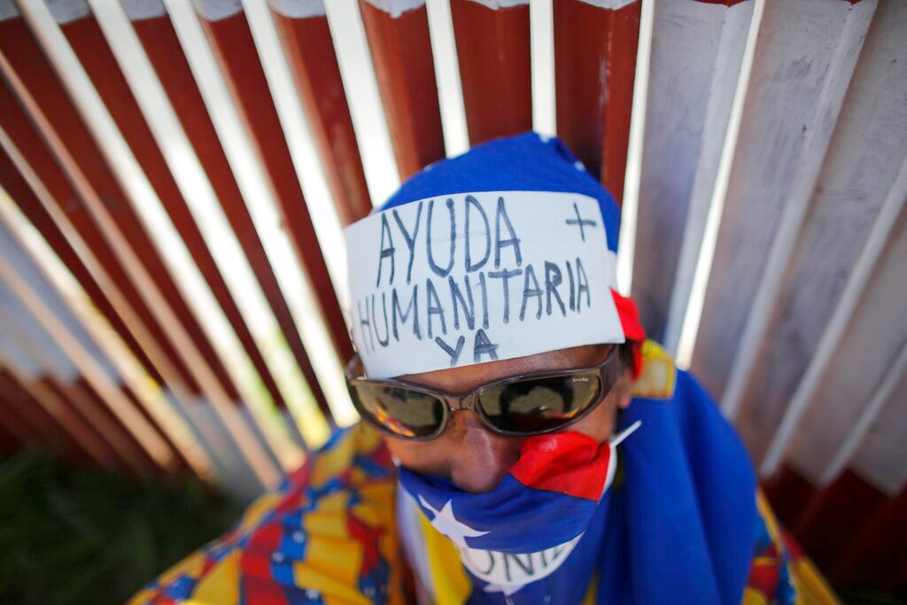 En esta foto del 23 de febrero de 2019, un simpatizante de la oposición lleva un cartel en su frente que dice “Ayuda Humanitaria ya”, durante una manifestación que instaba a los soldados a que dejaran ingresar asistencia humanitaria de Estados Unidos, en Caracas, Venezuela.