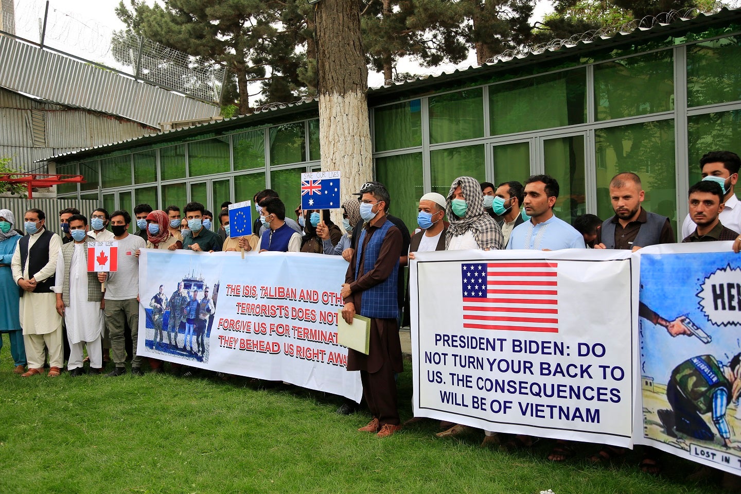 Des interprètes afghans ayant travaillé pour les forces américaines et de l’OTAN tenaient des drapeaux de plusieurs nations concernées et de l’UE lors d’un rassemblement à Kaboul, le 30 avril 2021. Leurs pancartes exprimaient leur crainte pour leur vie, suite au retraite annoncé des troupes de ces pays.