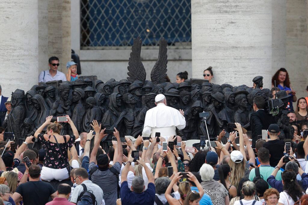Pope Francis unveils the sculpture on the theme of refugees and migration ' Angels Unawares ' by Canadian sculptor Timothy P. Schmalz, on Migrant and Refugee World Day, in St. Peter's Square, at the Vatican, Sunday, Sept. 29, 2019.