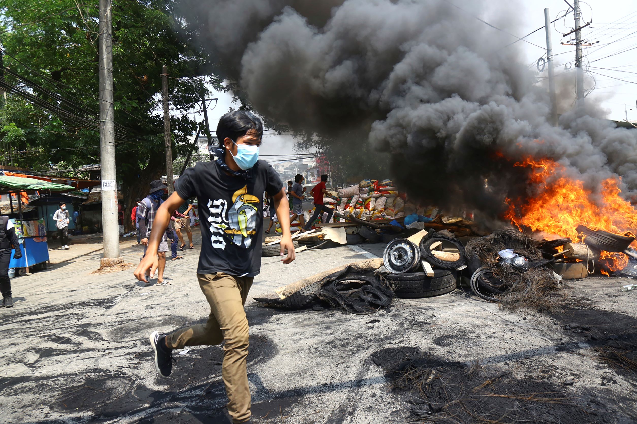 Anti-coup protesters run during a demonstration in Yangon, March 28, 2021.