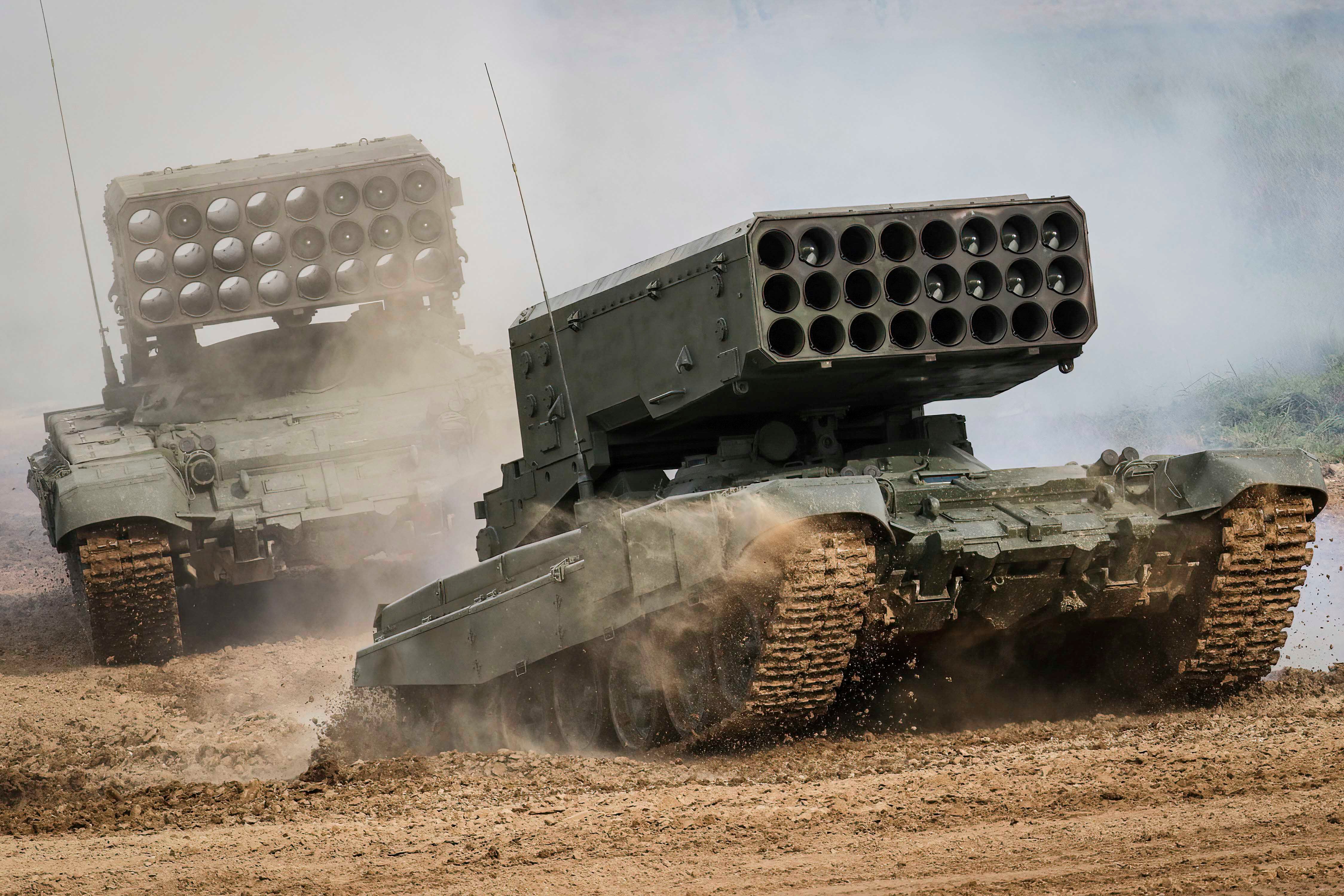 Deux lance-roquettes russes à multiples canons TOS-1A, photographiés lors de manœuvres en 2021. Ces armes peuvent tirer rapidement une salve de 24 roquettes de la série MO.1.01.04 avec des ogives thermobariques dont la portée est de 6 à 8 kilomètres. 