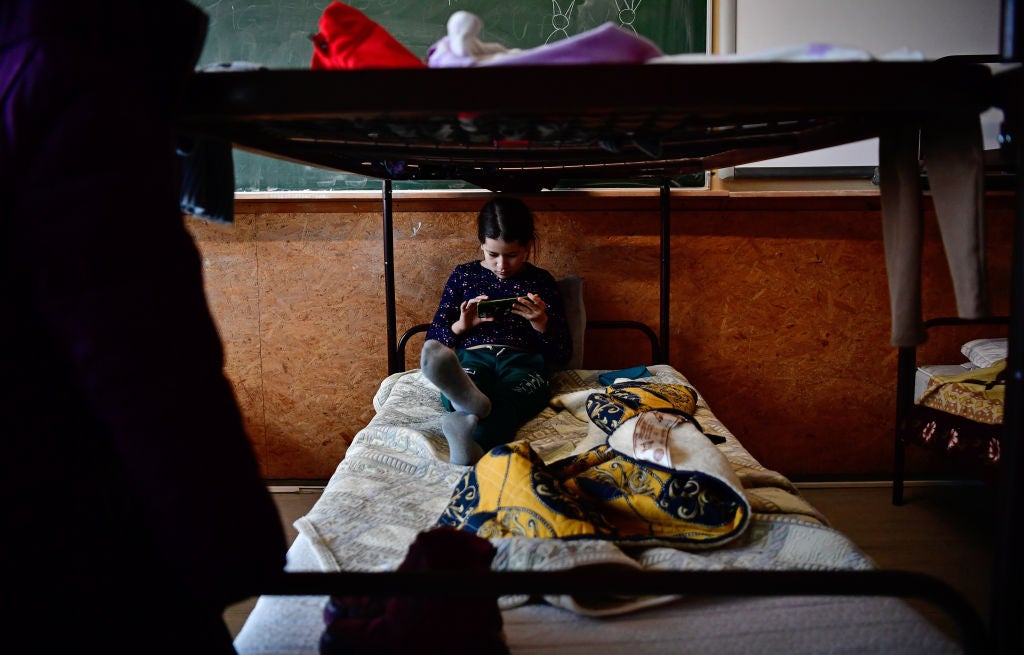 A girl looks at her phone on a bed