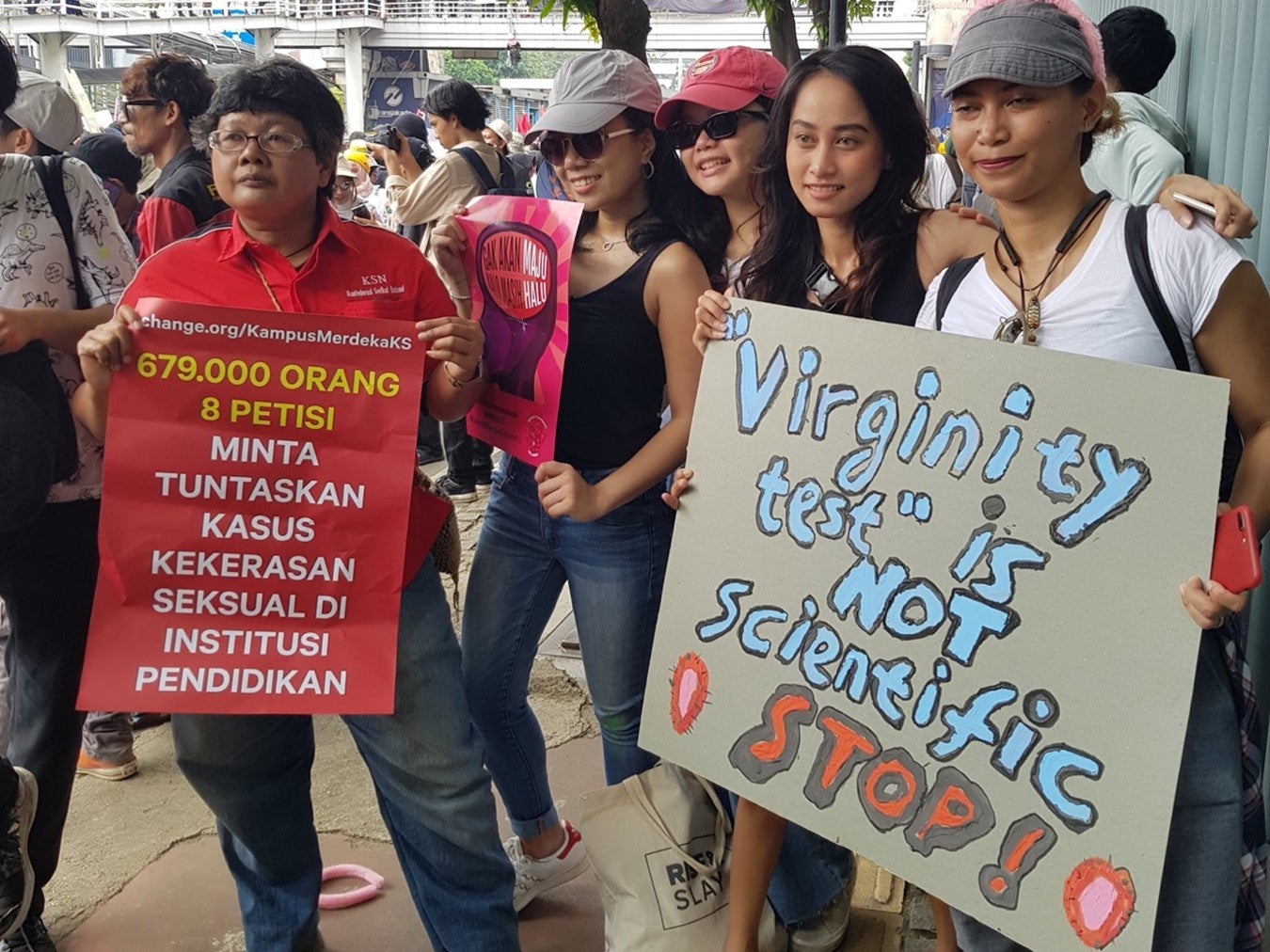 People protest holding signs