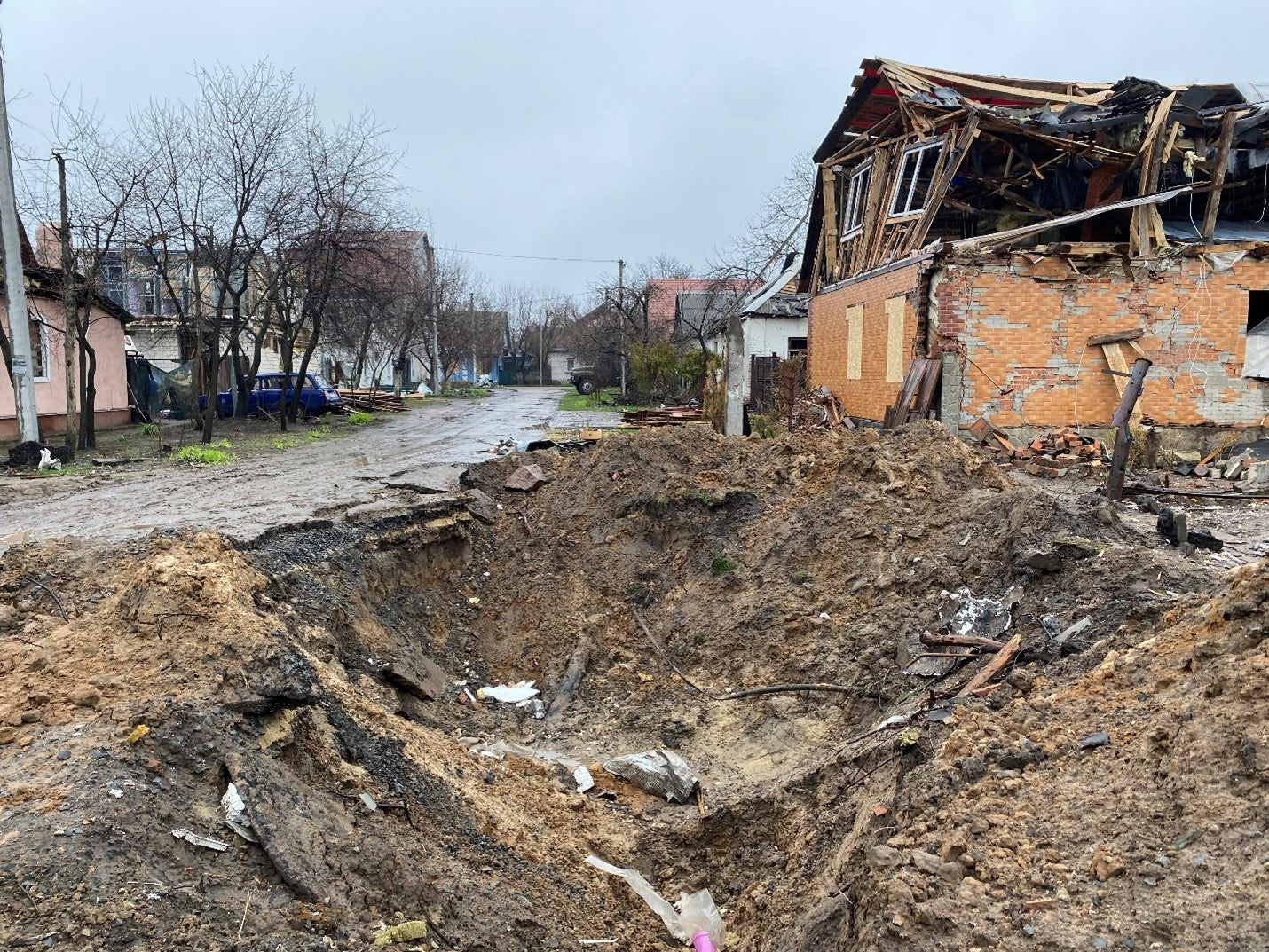 Impact crater and damage to a group of homes