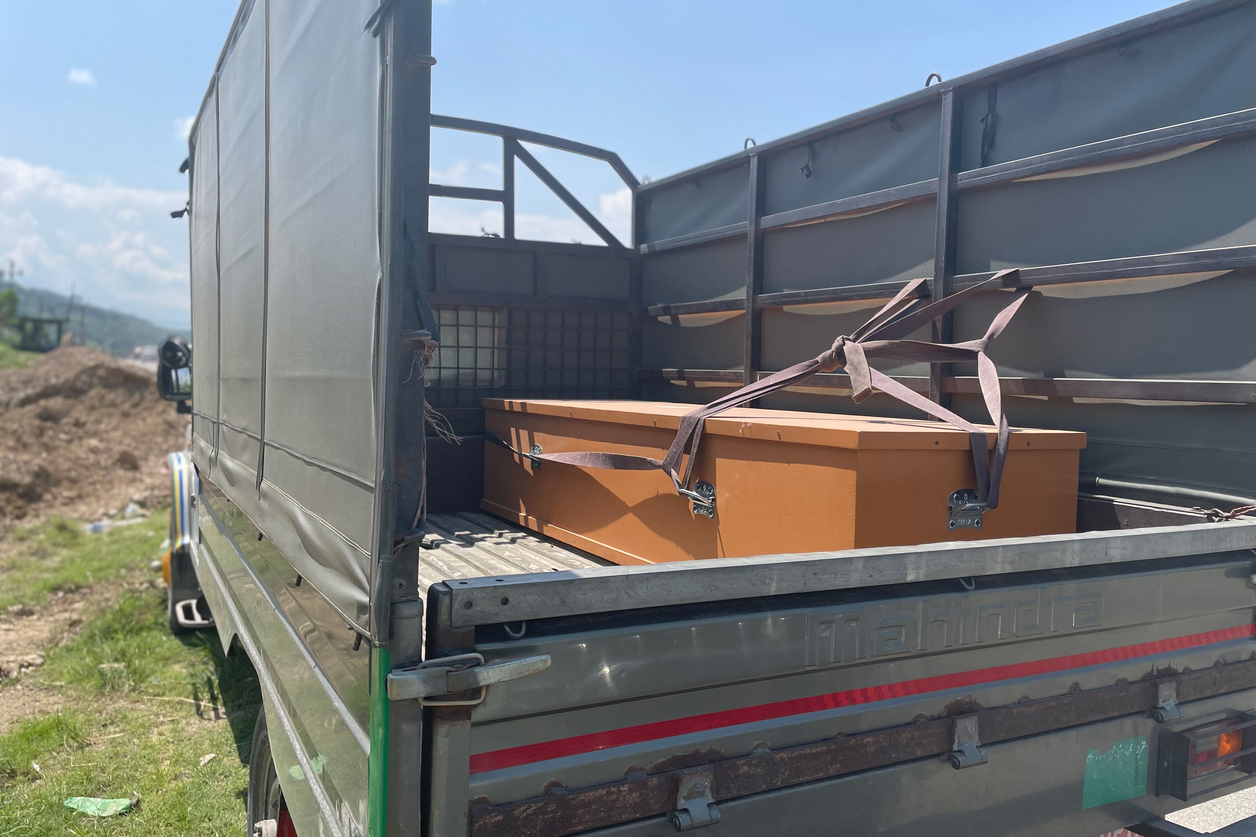 A casket lies on the back of a truck