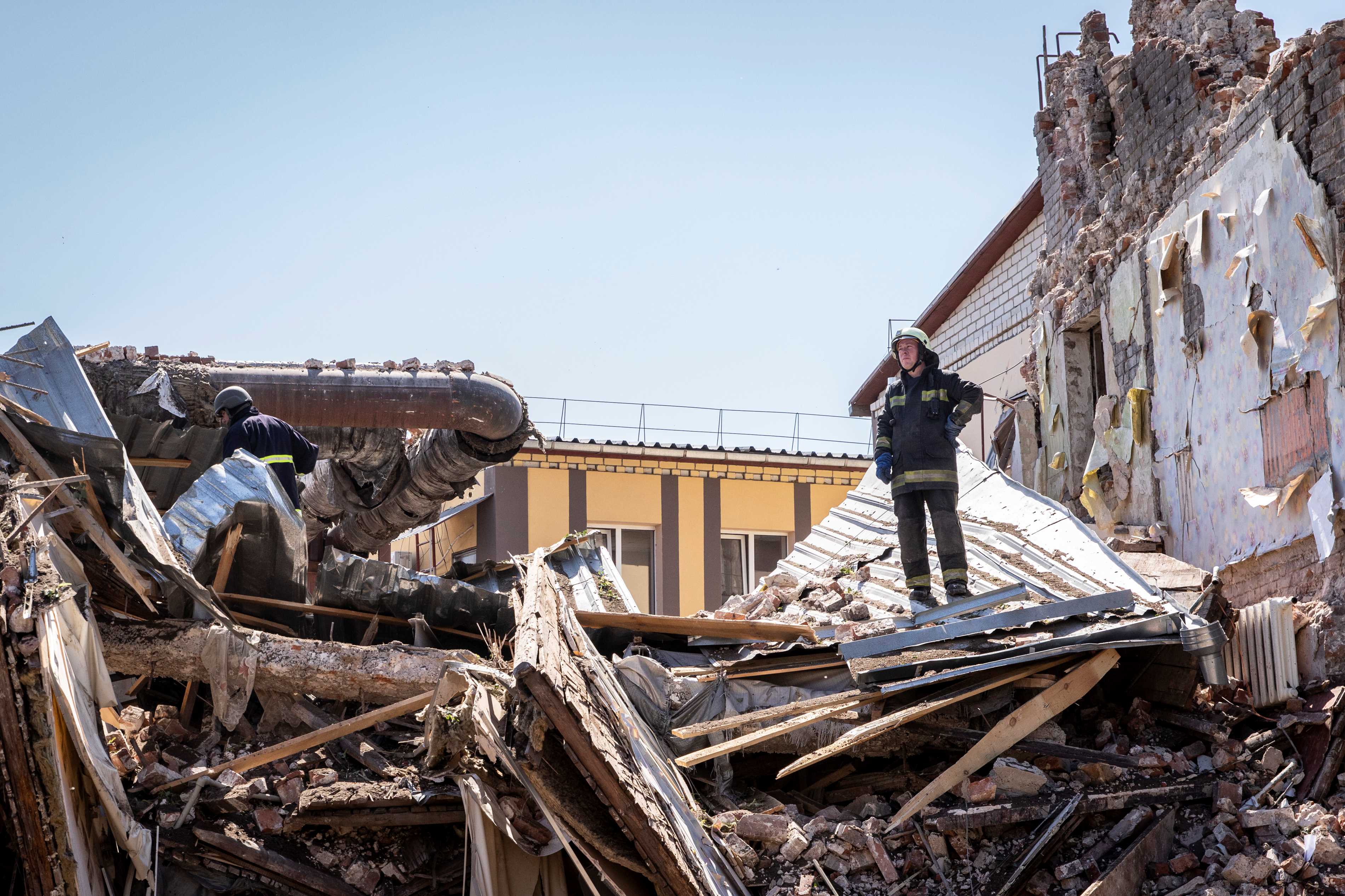 Un bombero se para sobre los escombros de un edificio destruido por el impacto de un misil de crucero ruso, que también hirió a varios civiles, en Járkov, Ucrania, el 9 de julio de 2022.
