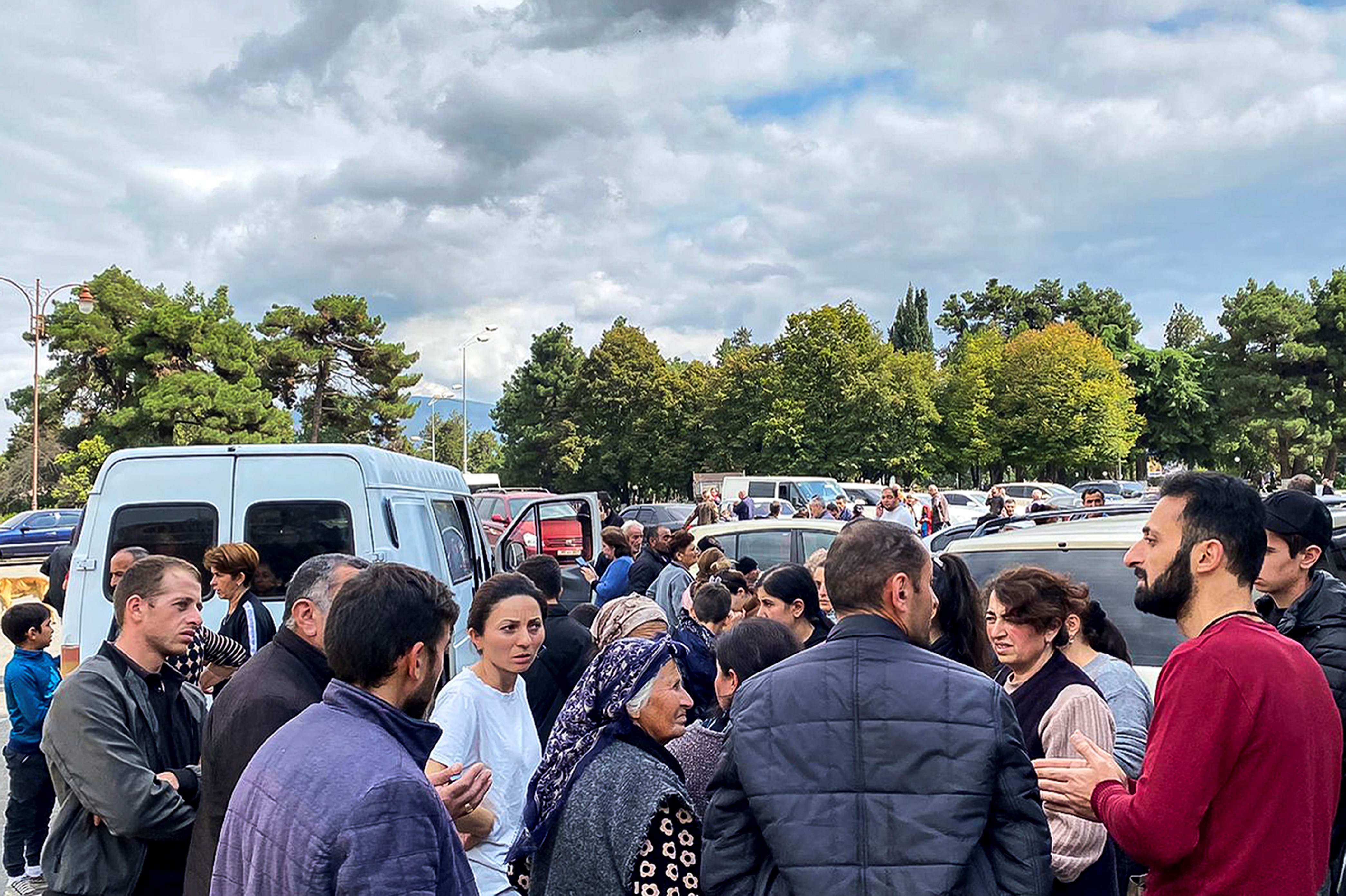 Des habitants du Haut-Karabakh rassemblés dans la capitale de la région, Stepanaker (nom arménien), ou Khankendi (nom azéri), écoutaient un employé du gouvernement local (à droite, portant un pullover rouge) qui tentait de les rassurer alors qu’une fusillade avait lieu non loin de là, le 21 septembre 2023. 