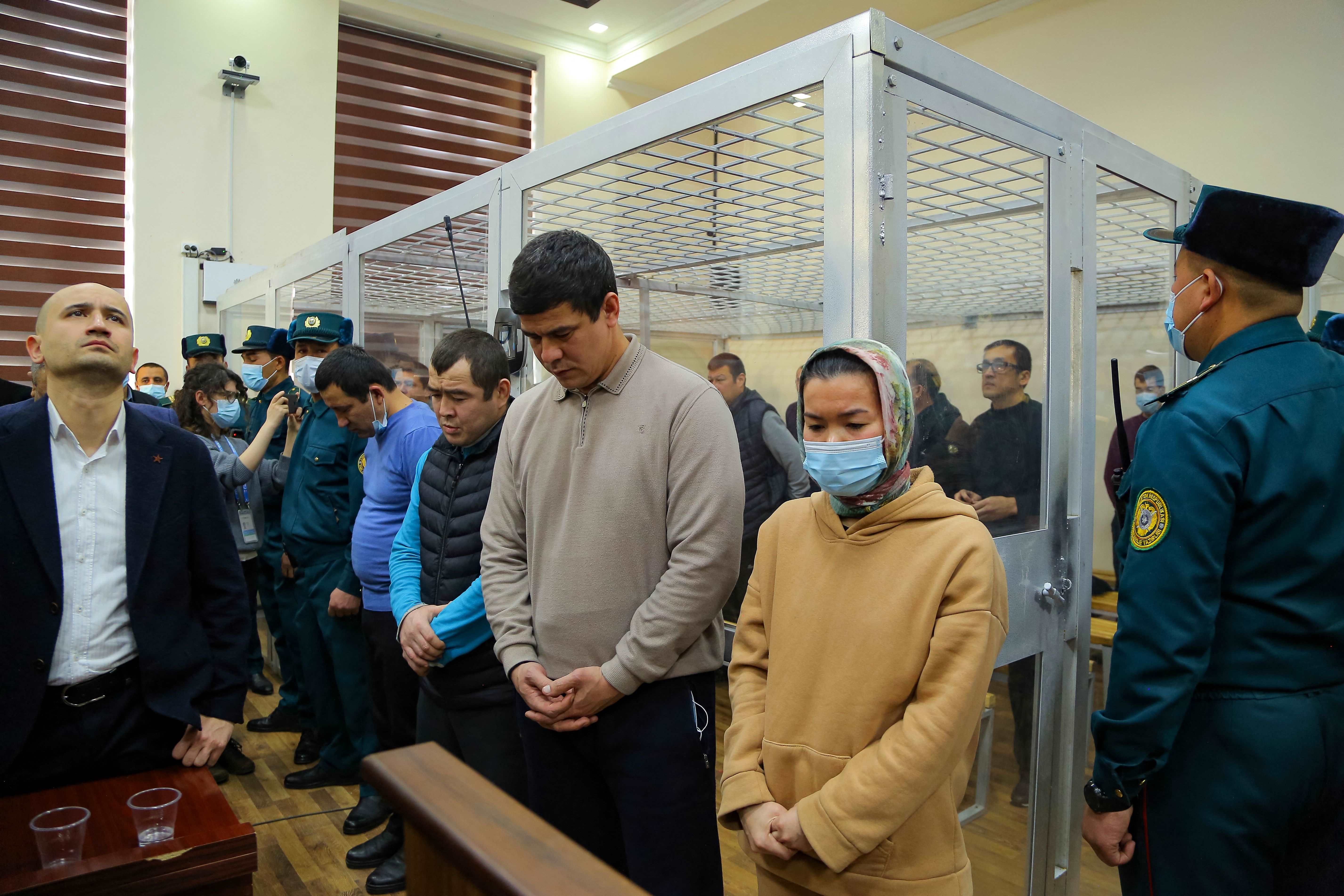 Defendants stand in a courtroom 