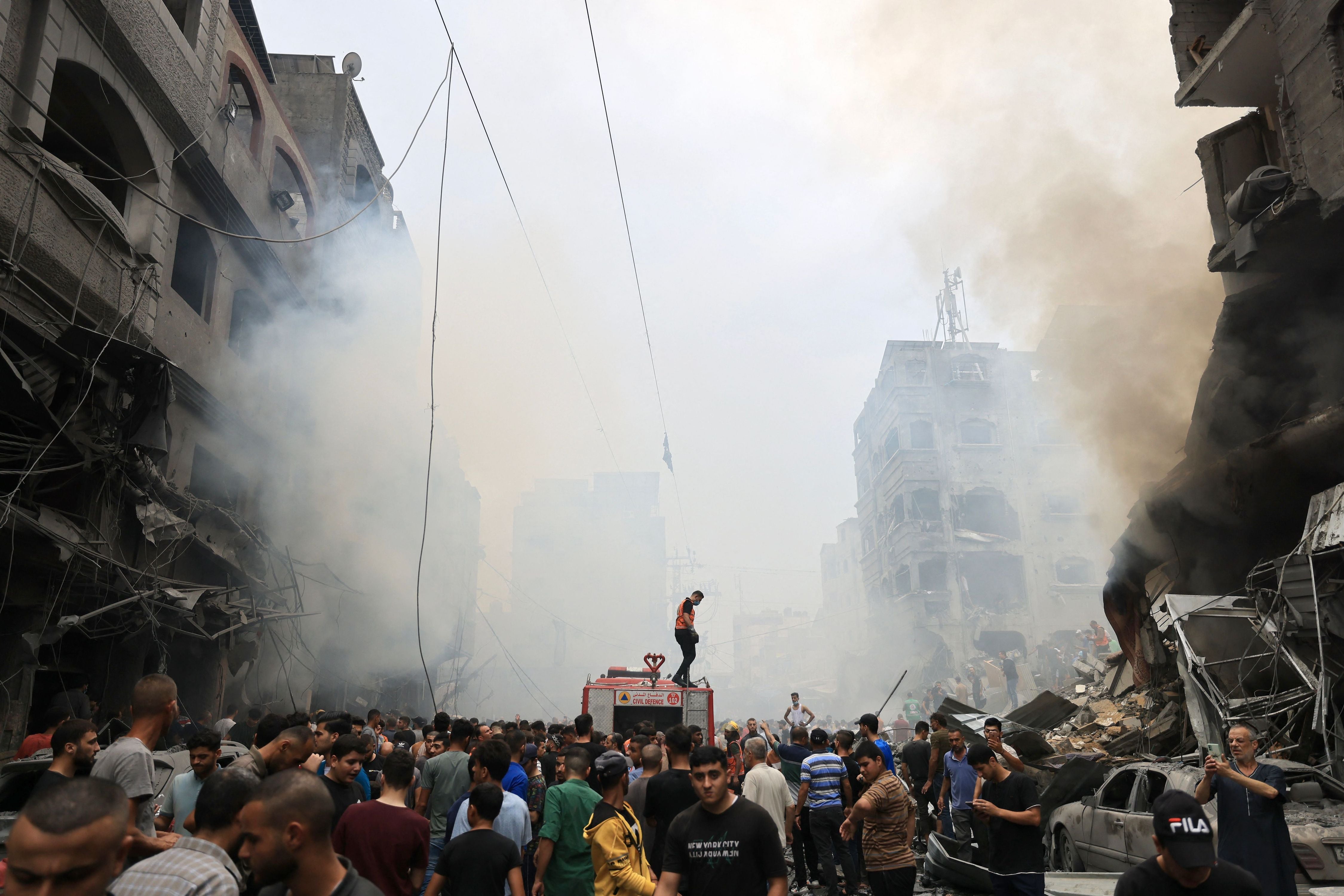 فلسطينيون يبحثون عن ناجين إثر غارة جوية على مبانٍ في مخيم جباليا للاجئين في قطاع غزة، 9 أكتوبر/تشرين الأول 2023.