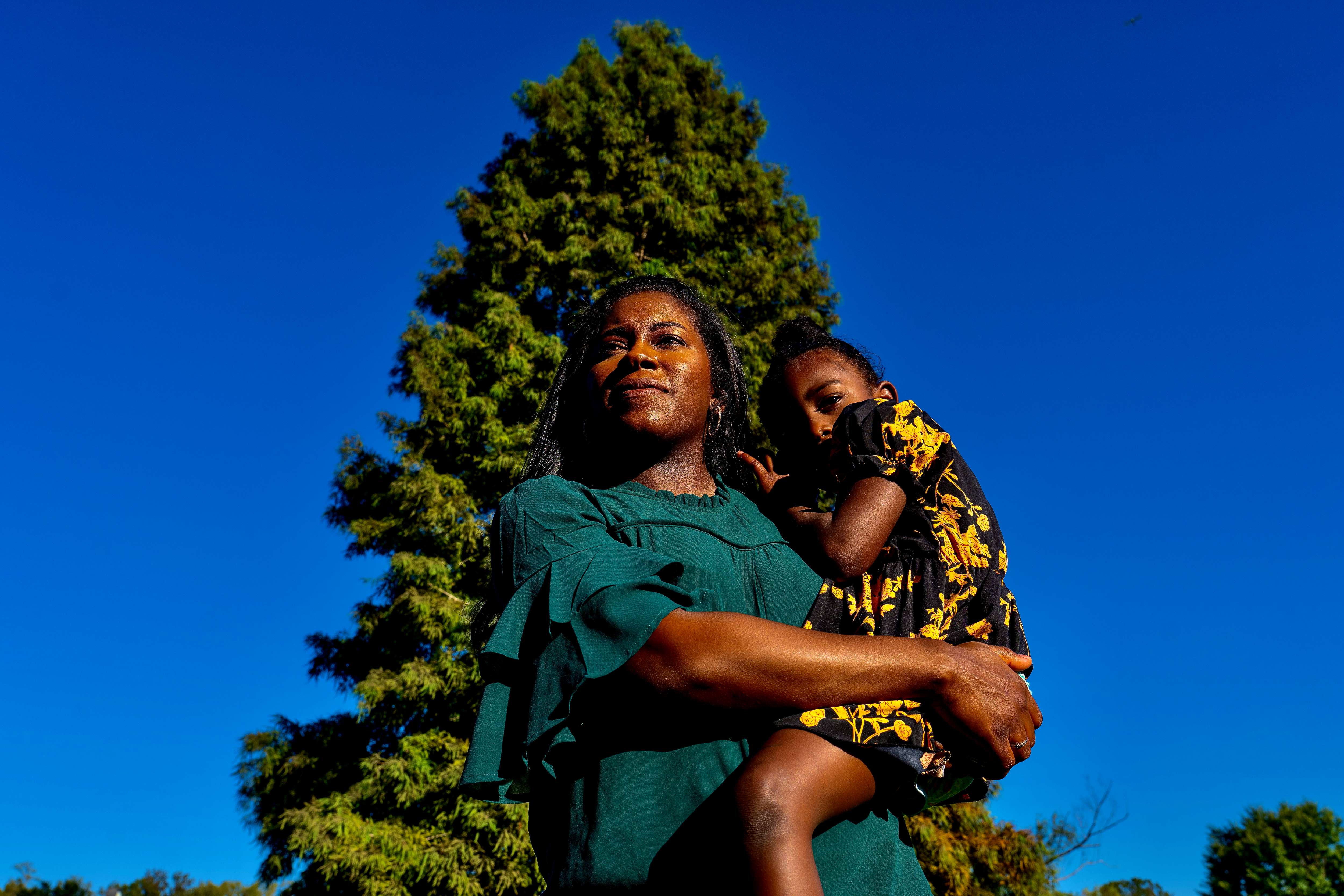 A woman poses for a photo holding her son