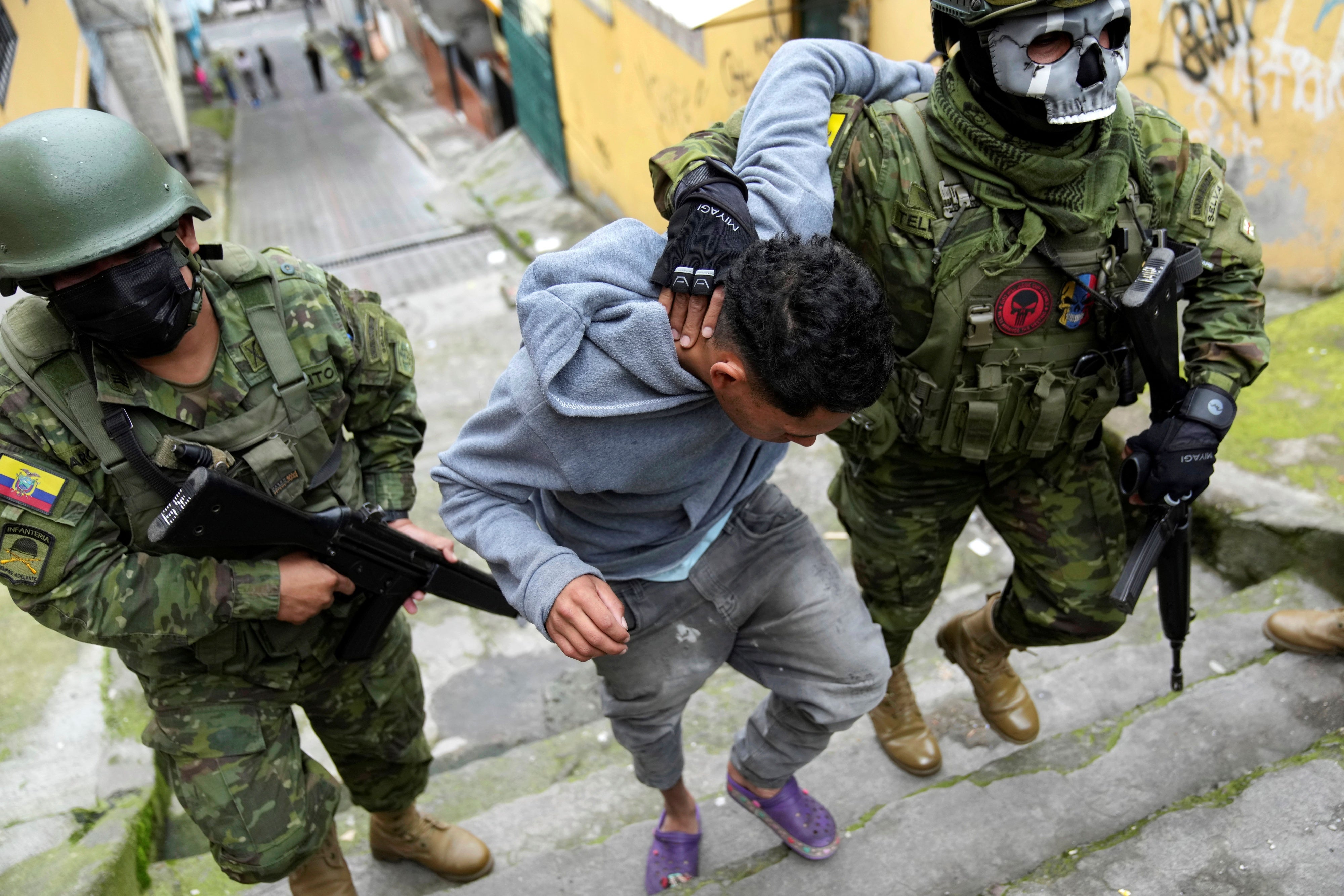 Soldados detienen a un joven para llevarlo a otra zona para comprobar si tiene tatuajes relacionados con pandillas, mientras patrullan el lado sur de Quito, Ecuador, viernes 12 de enero de 2024.