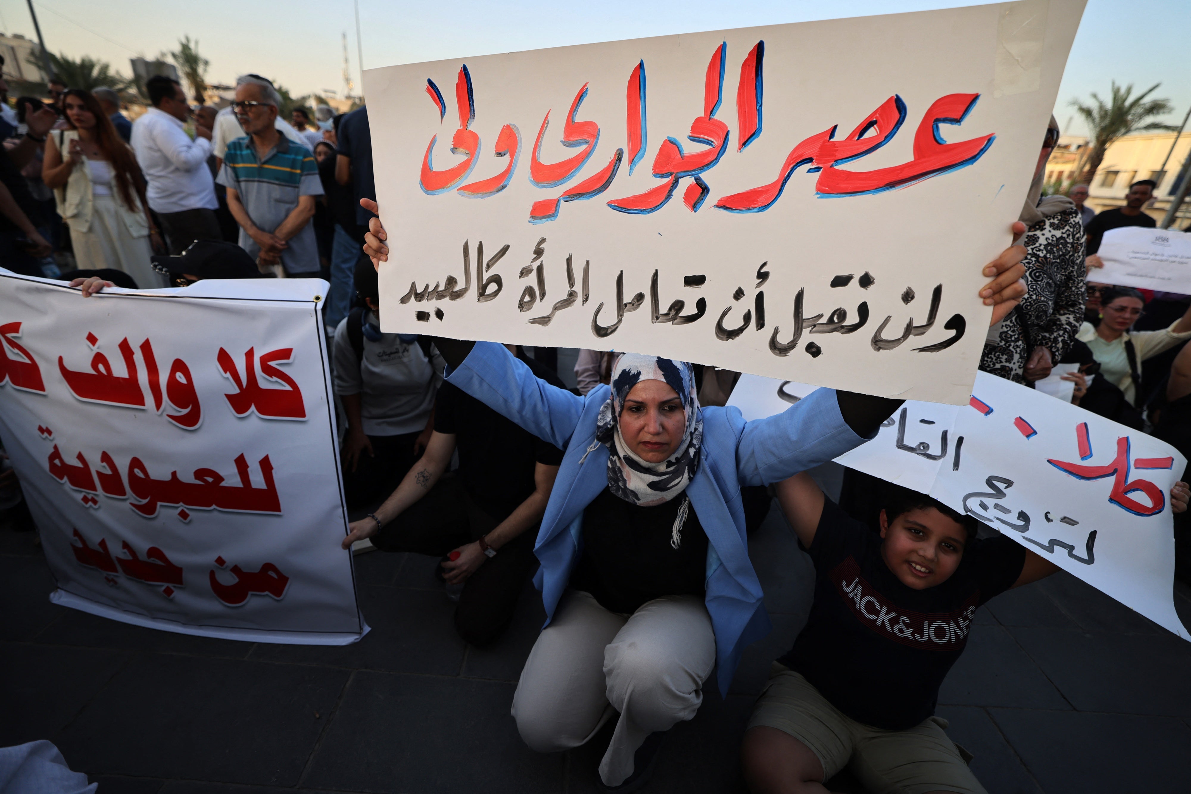 Une femme irakienne brandissait une pancarte lors d’une manifestation contre un projet de loi sur le mariage qui porterait atteinte aux droits des femmes et des filles, tenue sur la place Tahrir, à Bagdad, en Irak, le 8 août 2024.