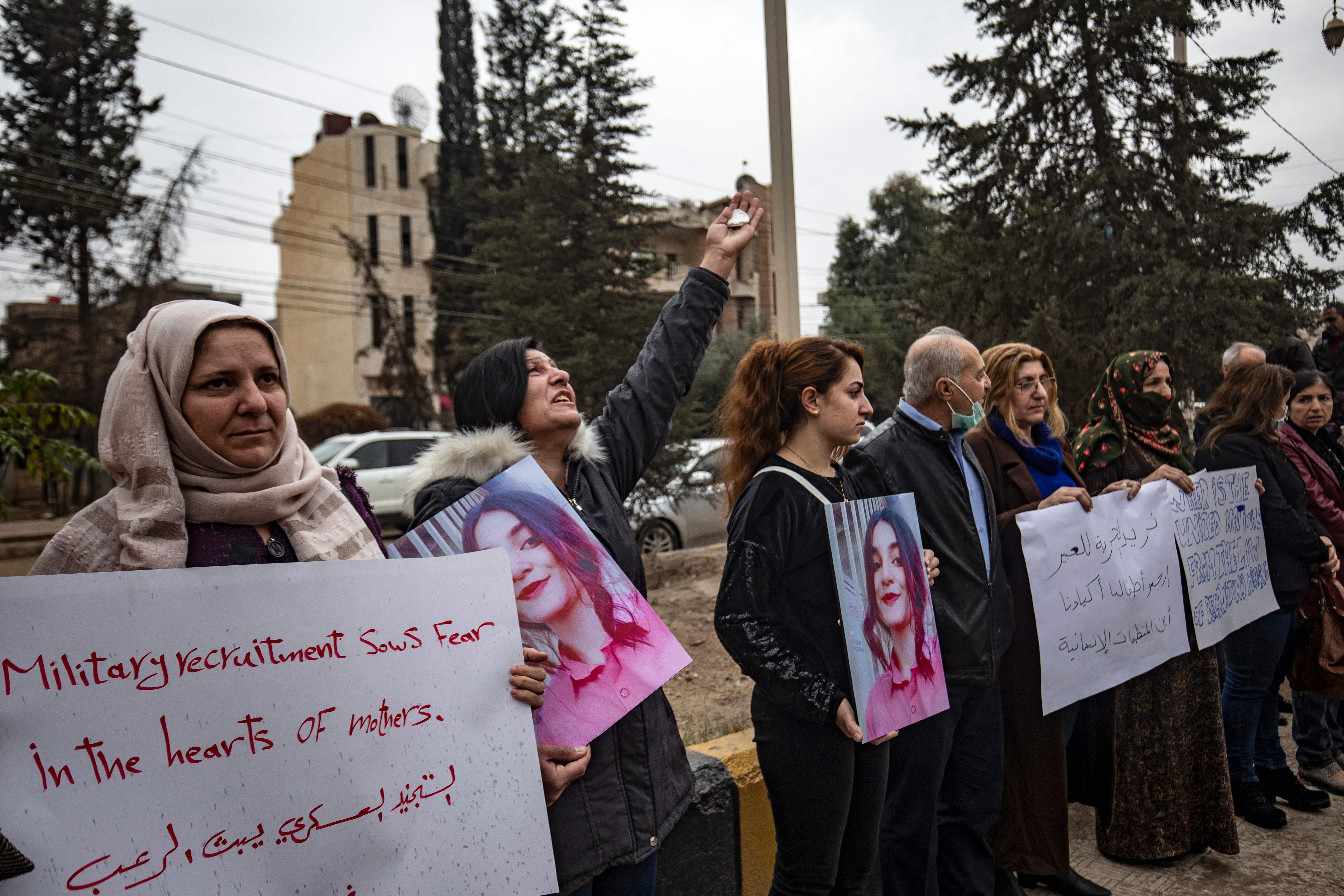 Kurdine Sûrî li derveyî avahiyeke Neteweyên Yekbûyî xwenîşandan dikin, û banga alîkariyê li desthilatdarên Kurd ê li Sûriyê dikin ji bo azadkirina keçên ku hatine revandin û tevlî şer hatine kirin, li bajarê Qamişlo yê li bakurê rojhilat, 28ê Mijdara 2021an. 