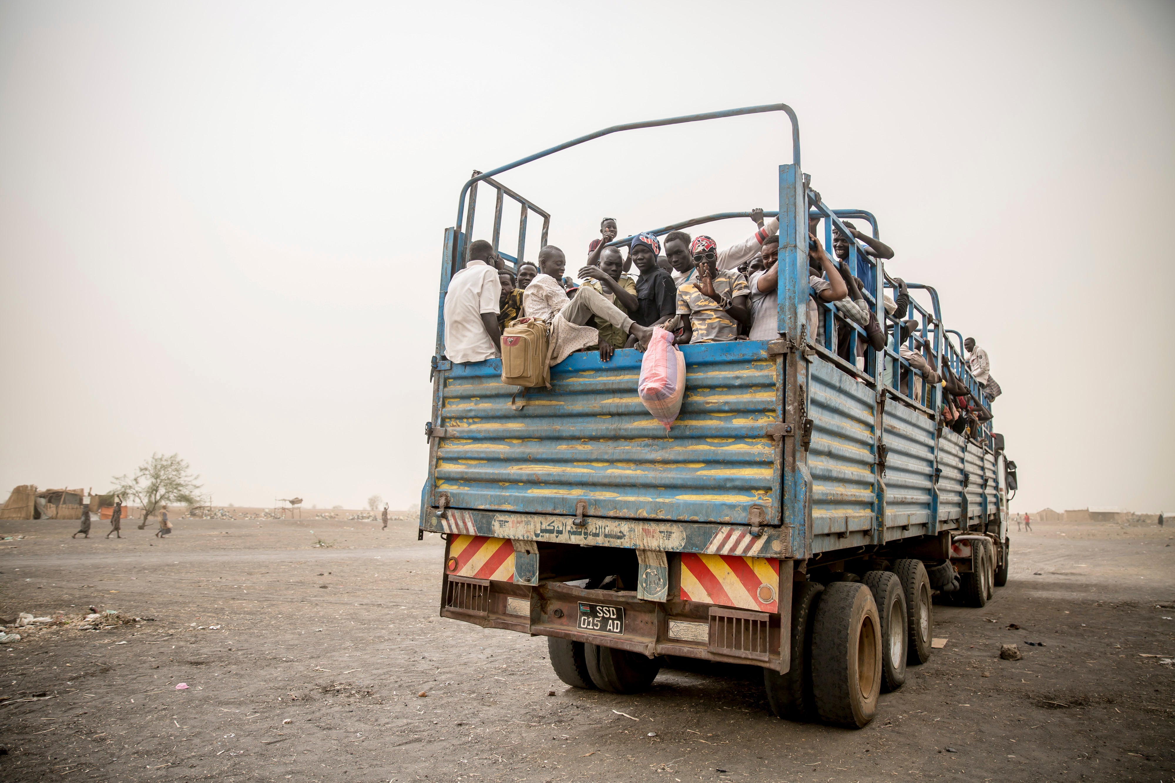 Des réfugiés sont transportés dans des camions 