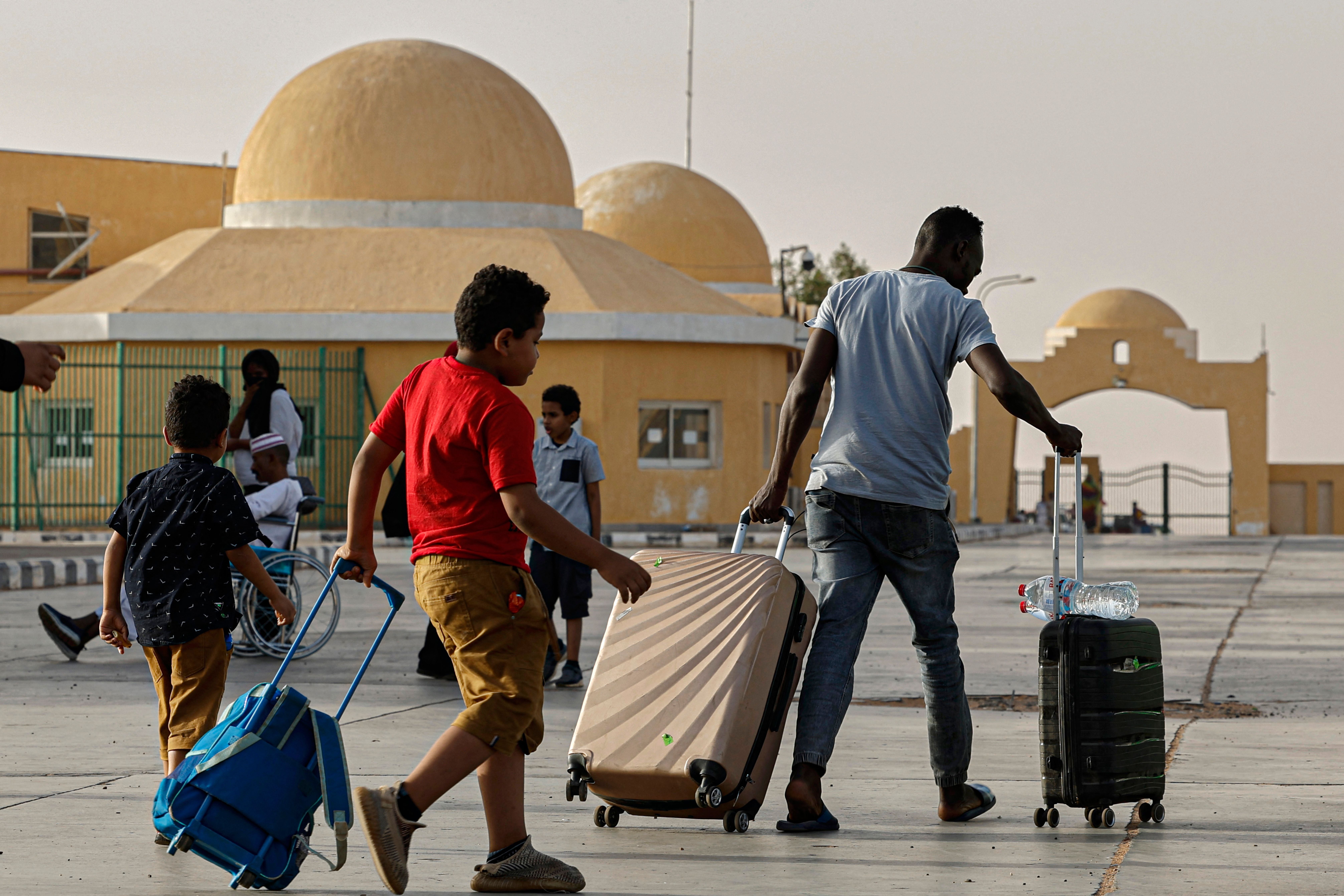 لاجئون يفرون من النزاع في السودان يعبرون إلى مصر عبر معبر أرقين البري في 12 مايو/أيار 2023.  © خالد دسوقي/أ ف ب عبر غيتي إيمجز 