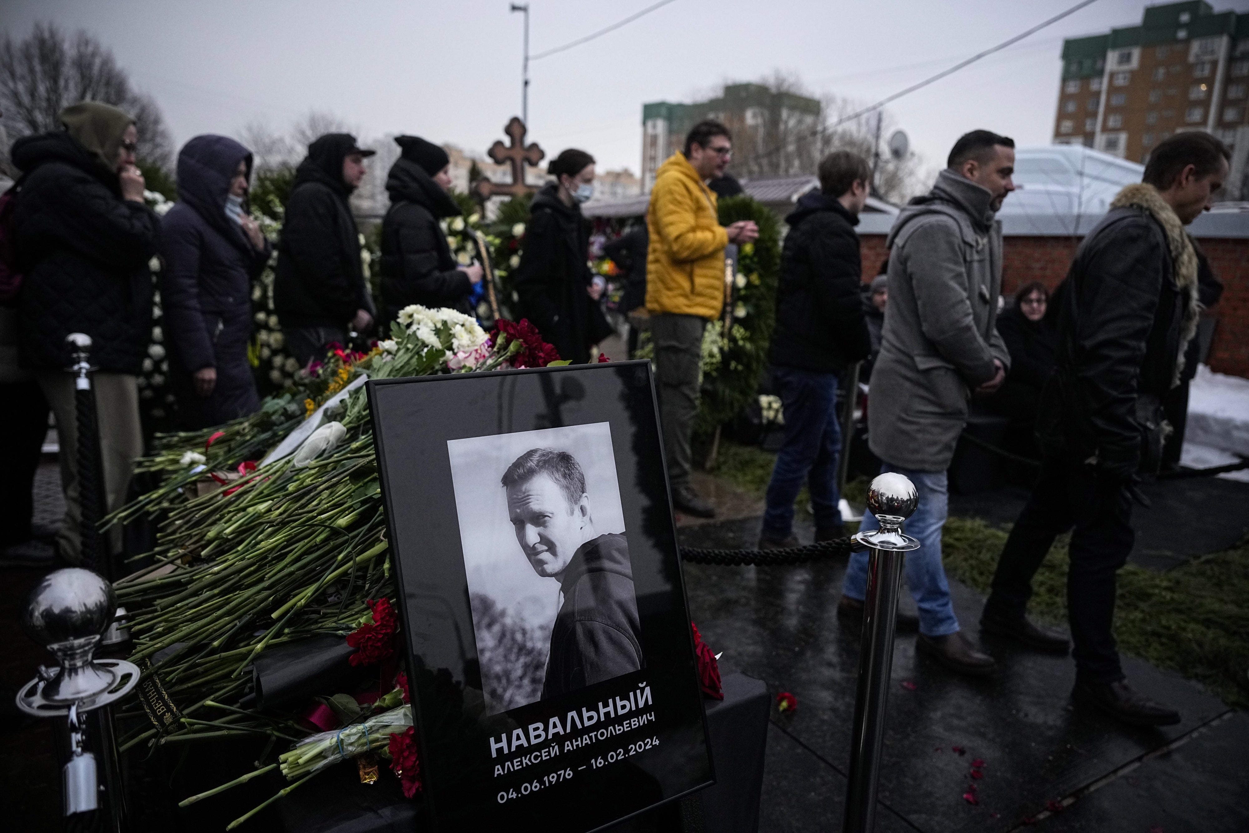 Des personnes en deuil passaient devant un portrait d'Alexeï Navalny lors des funérailles de l’ex-leader de l'opposition russe au cimetière Borisovskoïe, à Moscou, le 1er mars 2024.