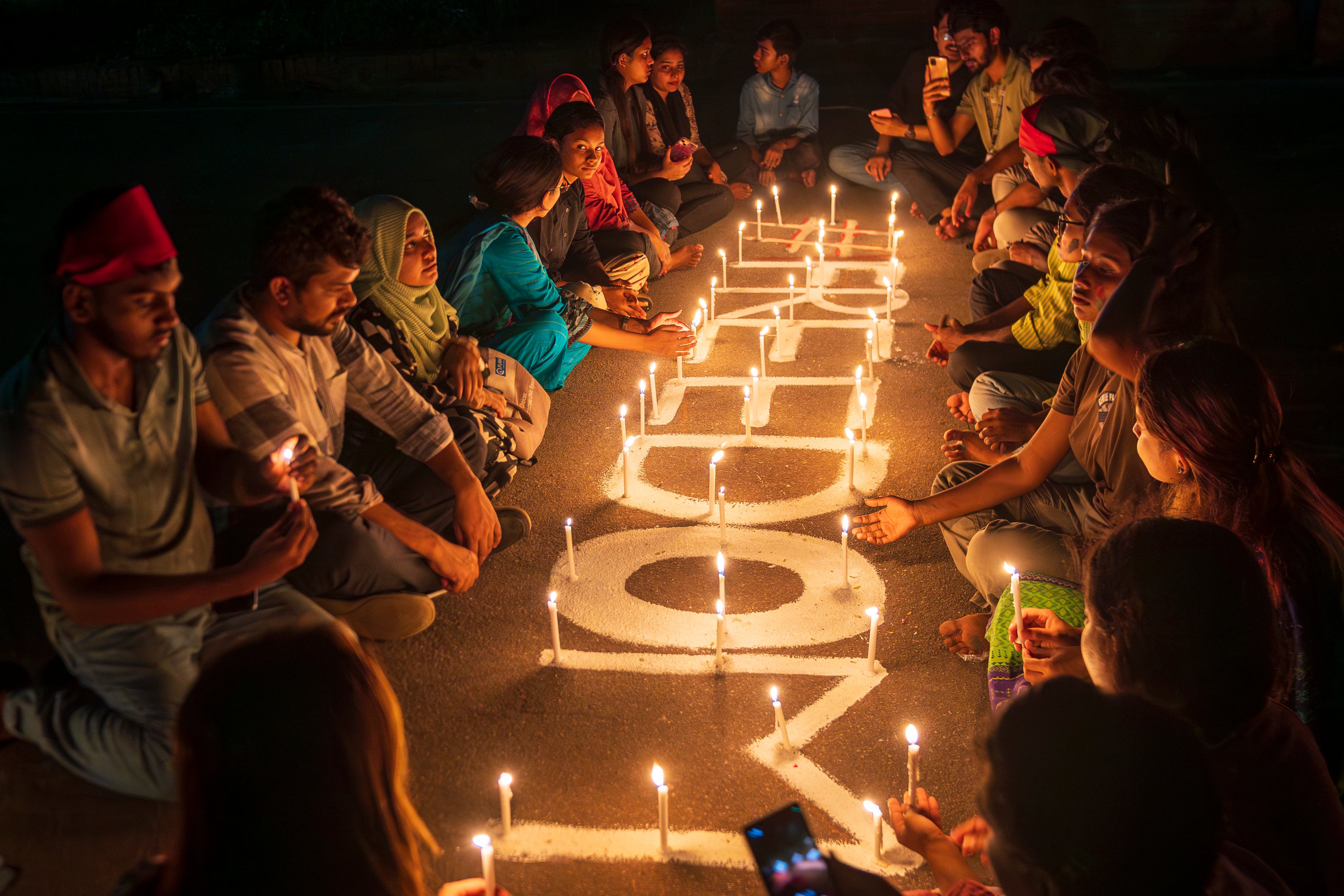 Varias personas encienden velas frente al parlamento nacional para rendir homenaje a los estudiantes asesinados durante las protestas que pedían la dimisión del gobierno de Hasina, Dhaka, Bangladesh, 8 de agosto de 2024.