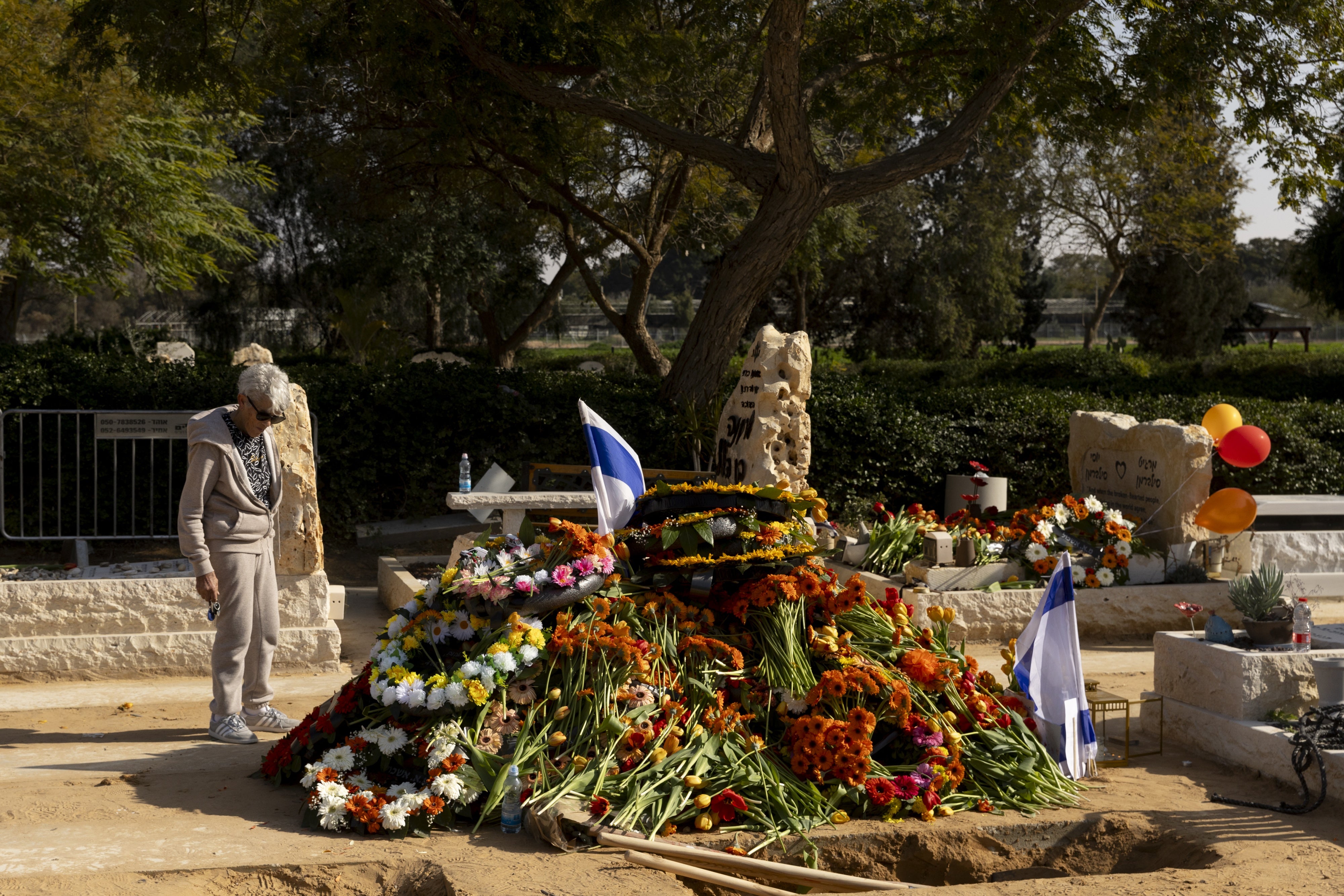 אישה אֲבֵלה ליד קברם של בני הערובה שירי ביבס, כפיר ביבס ואריאל ביבס, לאחר הלווייתם בצוחר, ישראל, 26 בפברואר 2025.