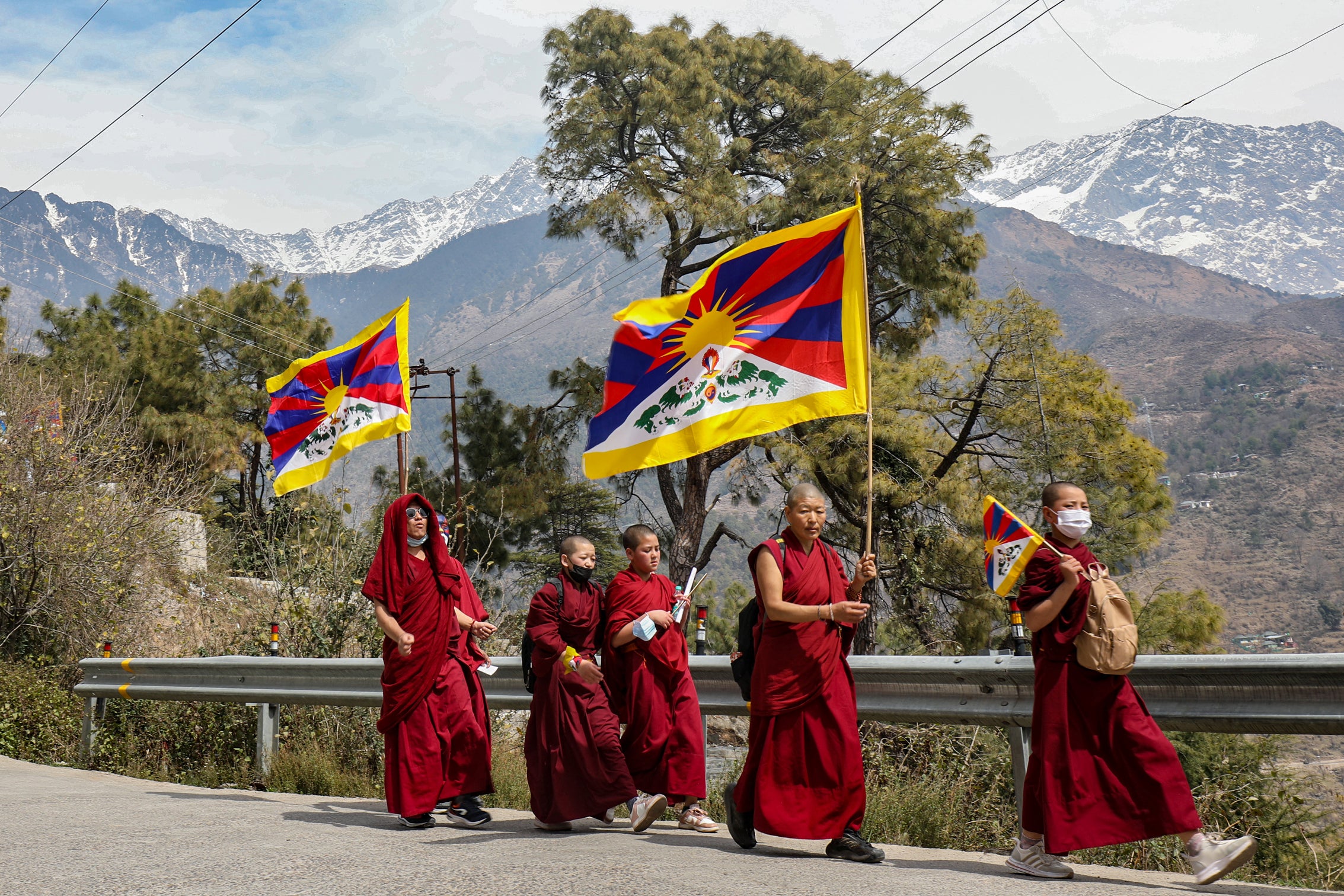 Des moines tibétains vivant en exil en Inde brandissaient des drapeaux tibétains lors d’une marche pour la paix tenue lors du 65ème anniversaire du soulèvement tibétain de 1959 contre la domination chinoise, près de Dharamsala, dans le nord de l’Inde, le 10 mars 2024. 