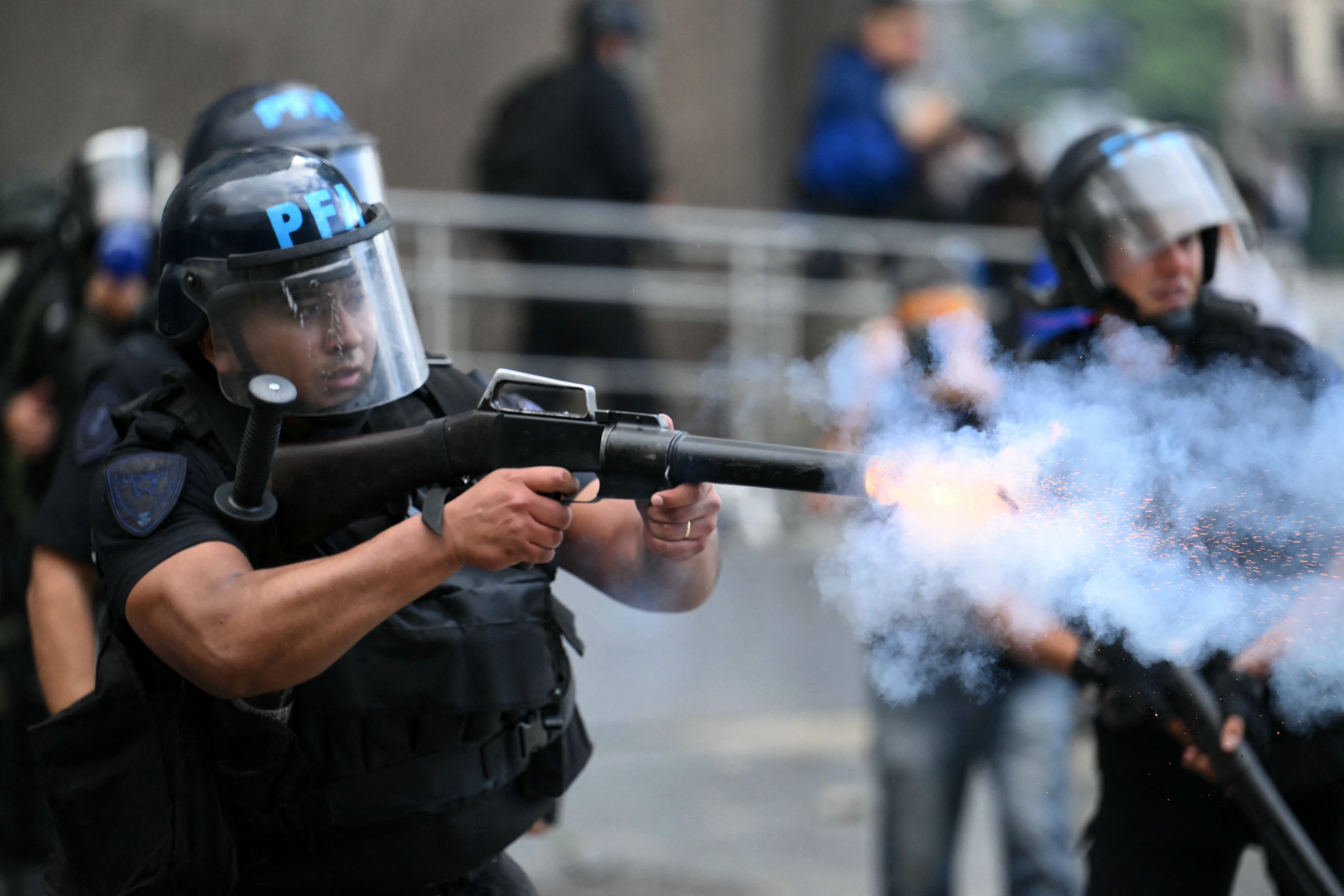 Un policía de la Policía Federal Argentina dispara un cartucho de gas lacrimógeno contra manifestantes durante una protesta de jubilados que piden mejoras en sus jubilaciones y acceso a medicamentos gratuitos, entre otras demandas, en Buenos Aires el 12 de marzo de 2025. 