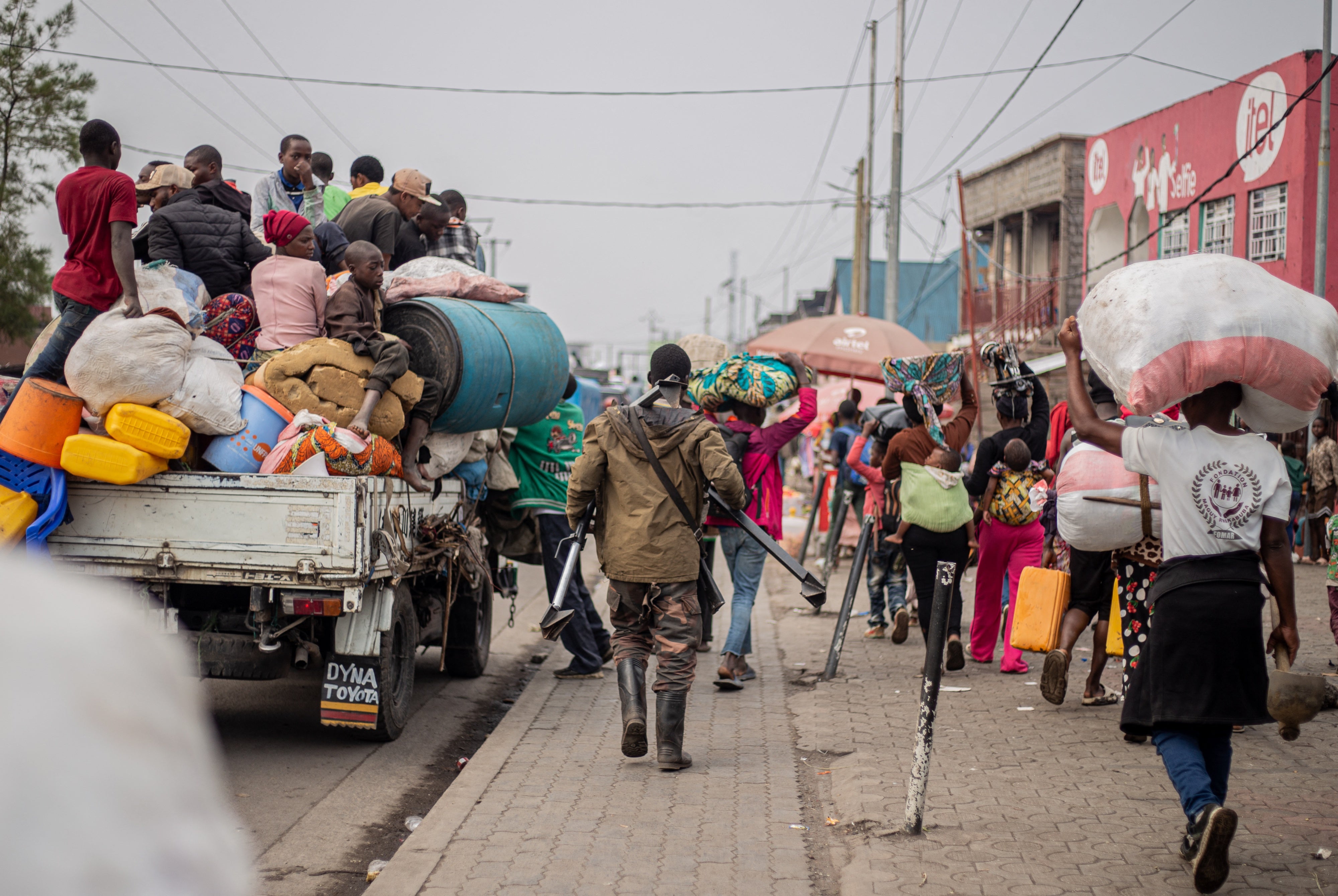 A Wazalendo fight joins residents fleeing Kibati, DRC.