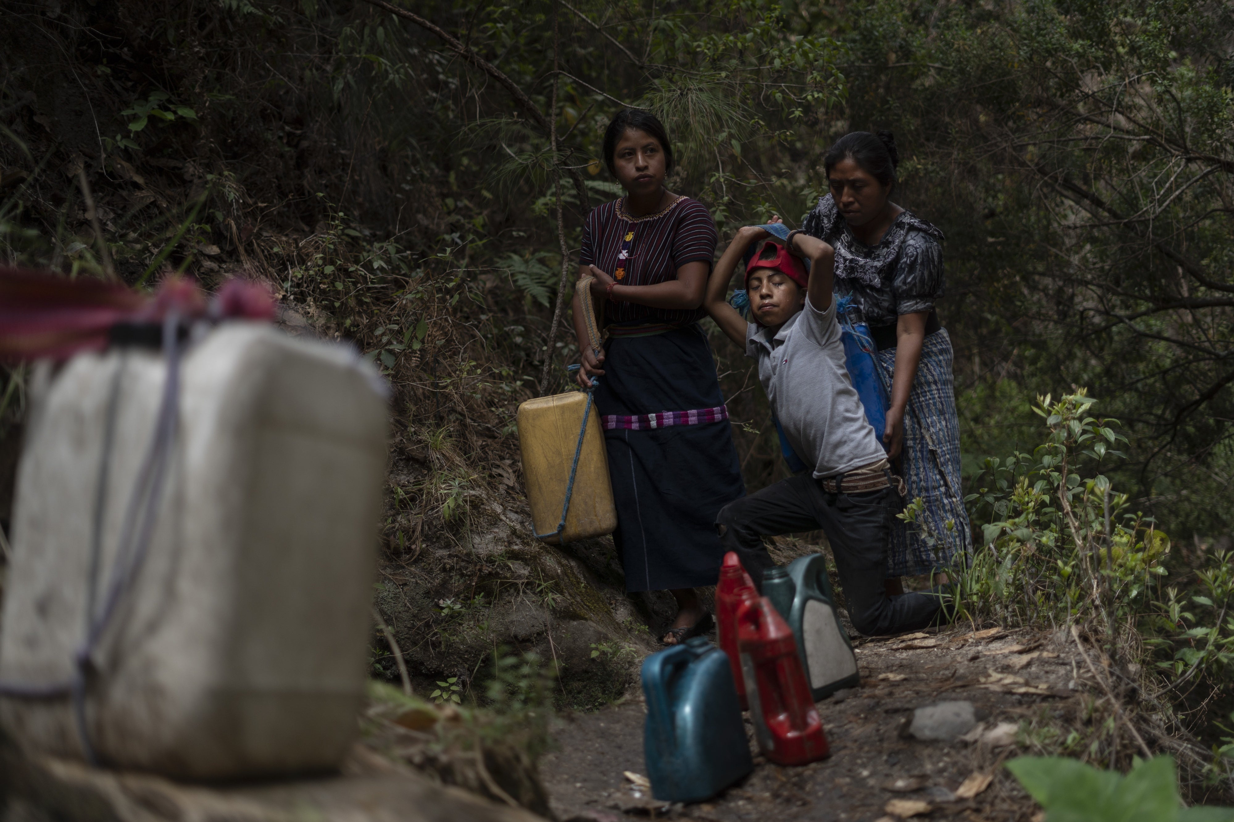 A woman and her children collect water 