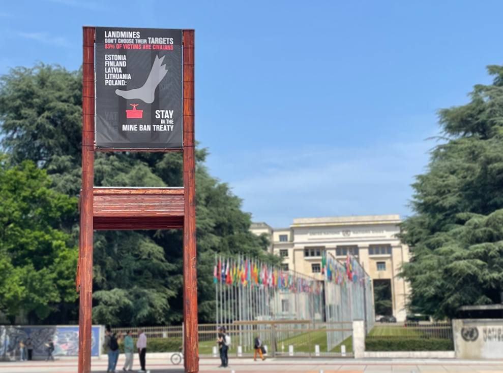 Ein Banner, das an der Skulptur „Broken Chair“ vor den Vereinten Nationen in Genf hängt, fordert Estland, Finnland, Lettland, Litauen und Polen dazu auf, im Minenverbotsvertrag zu bleiben und nicht aus ihm auszutreten, 11. Juni 2025.