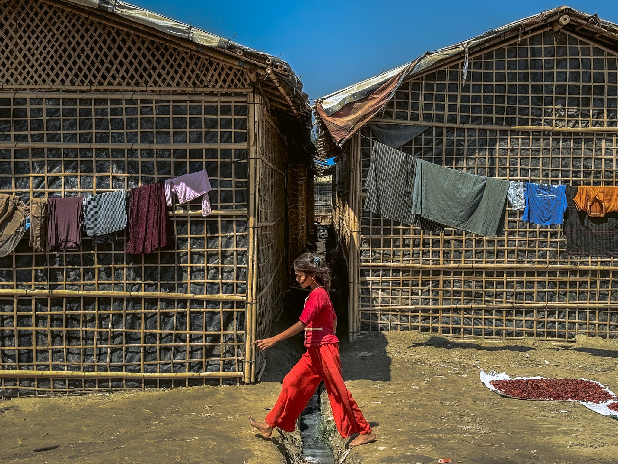 Une fille rohingya passe devant des abris dans un camp de réfugiés à Cox's Bazar, au Bangladesh, le 9 mars 2025.