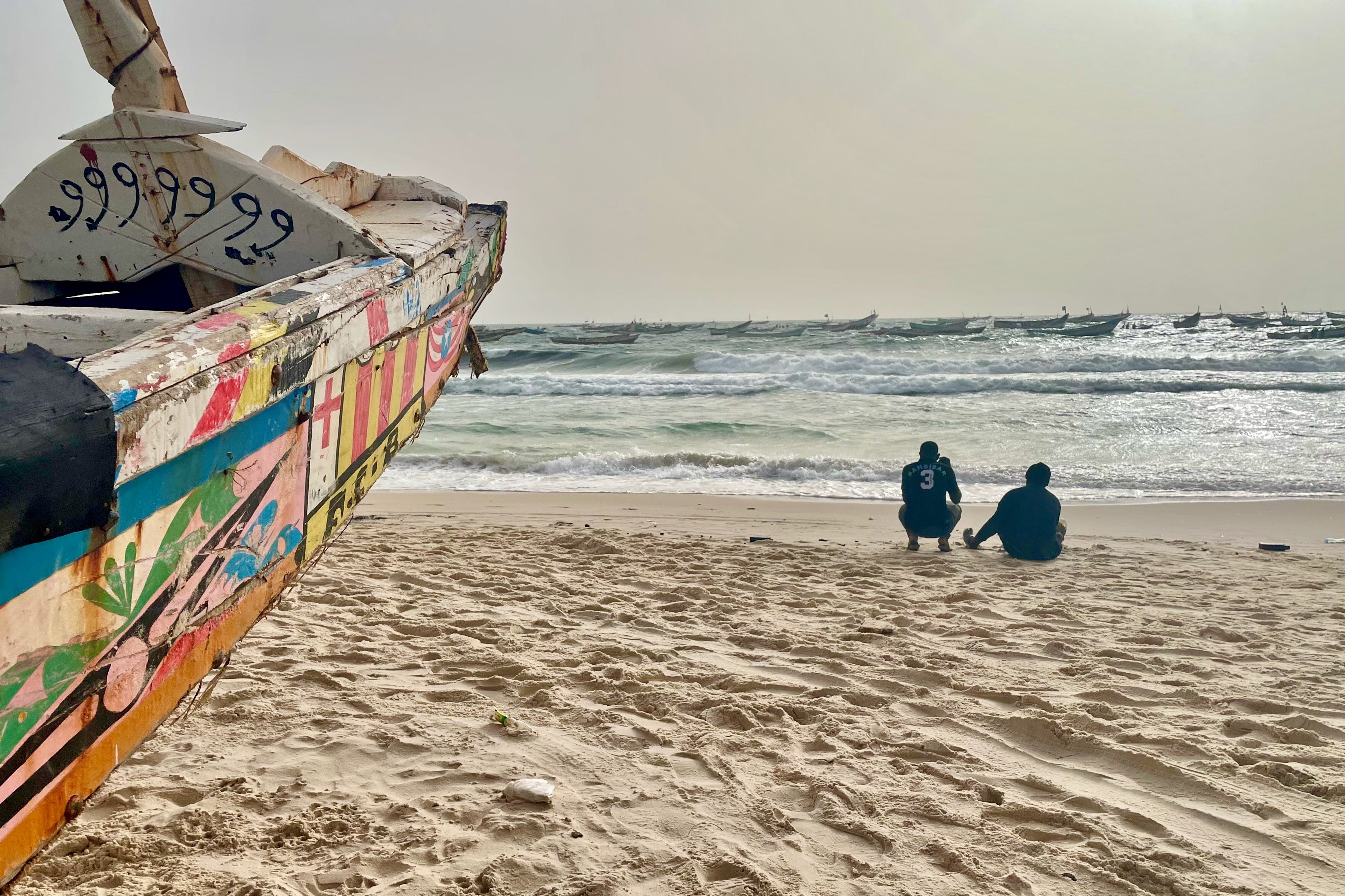 Deux hommes près d’une pirogue