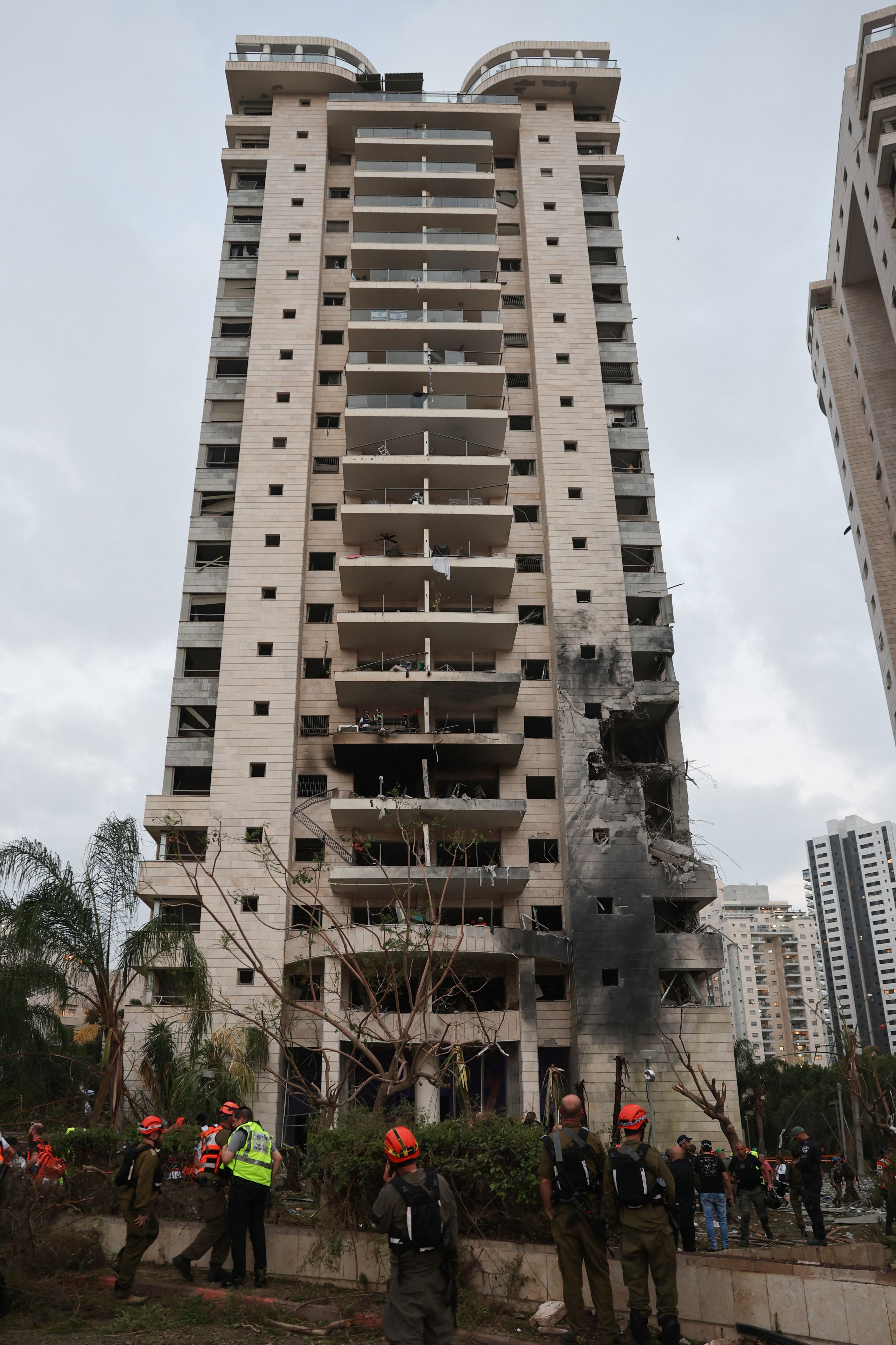 כיתוב: צוותי חירום והצלה בסמוך לבניין שניזוק מפגיעת טיל בליסטי איראני בפתח תקווה ב-16 ביוני 2025