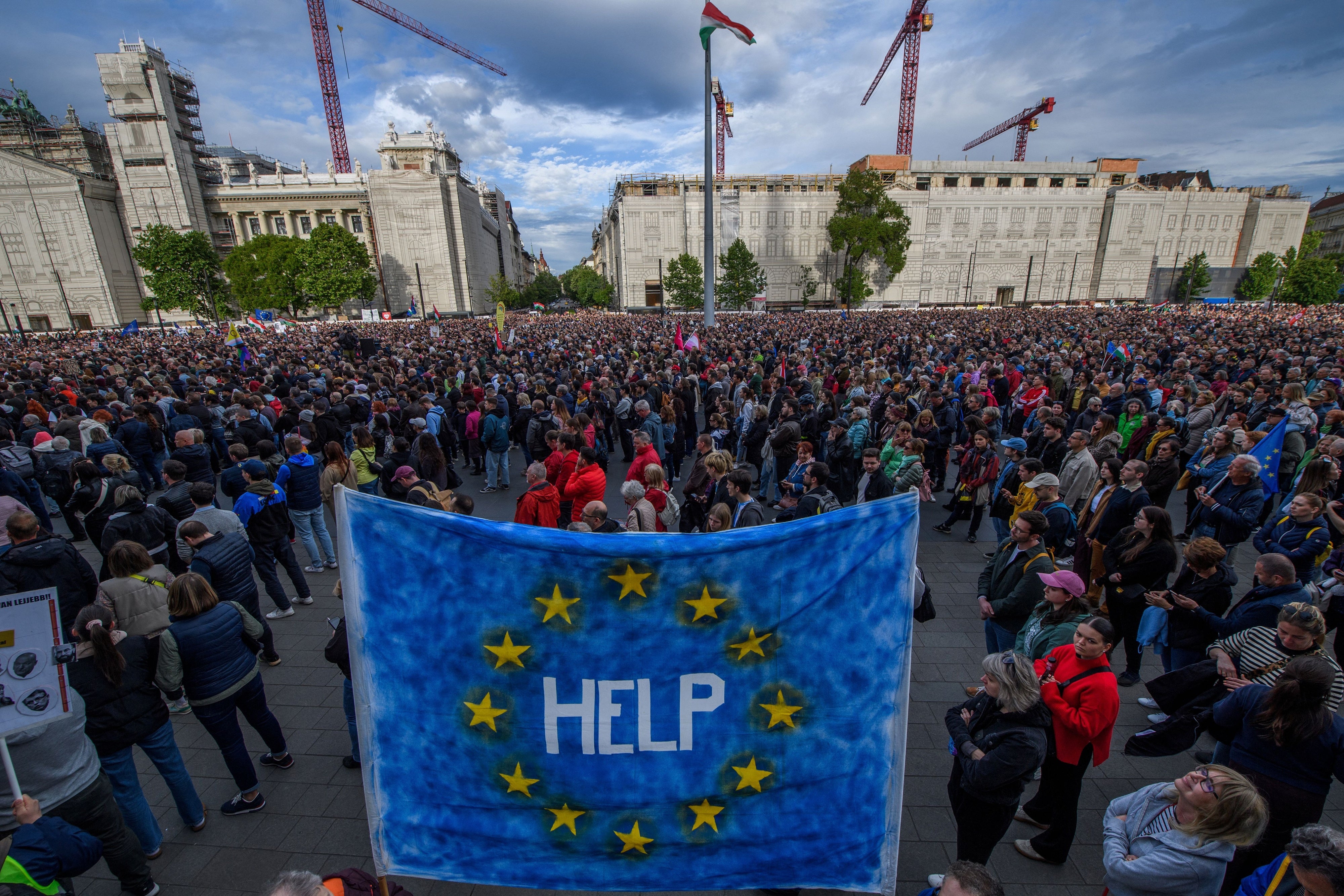 Un manifestant brandit un drapeau européen sur lequel est inscrit « help » (à l'aide) lors d'une manifestation à Budapest le 18 mai 2025 contre un projet de loi habilitant le gouvernement à sanctionner les organisations de la société civile et les médias qu'il considère comme une menace pour la souveraineté du pays. 