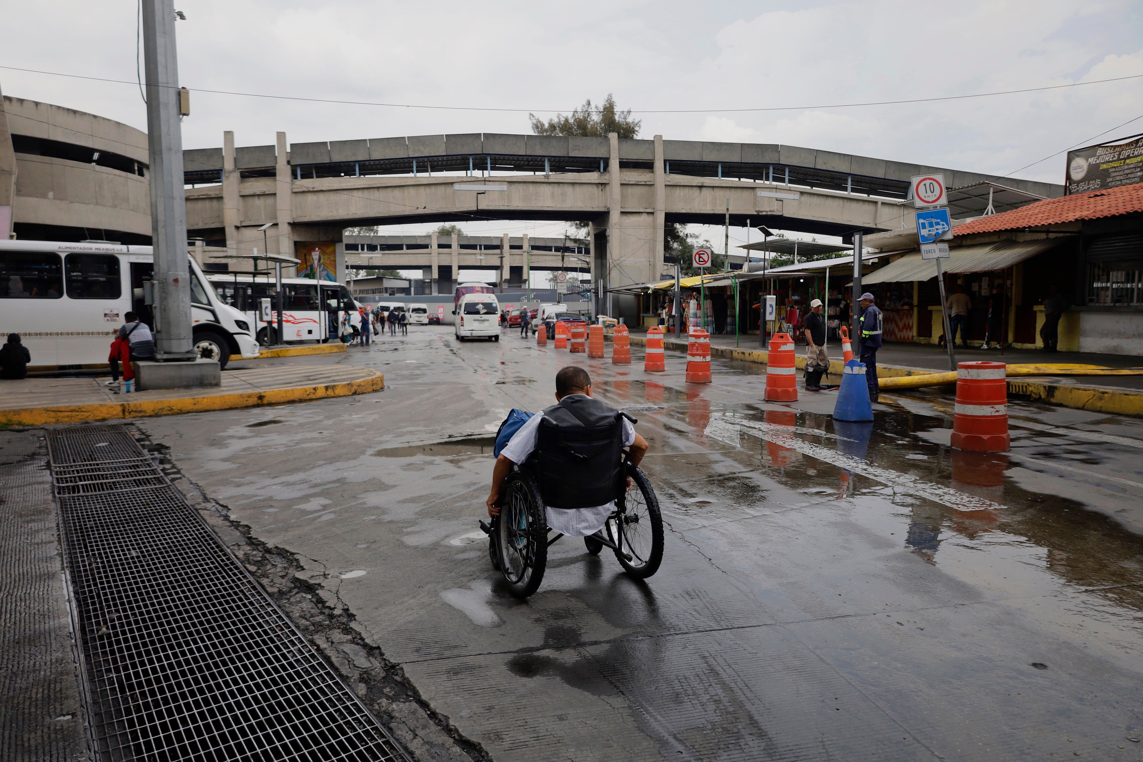 Una persona usuaria de silla de ruedas busca opciones para cruzar un paso deprimido mientras se realizan trabajos de desazolve después de una lluvia histórica en la Ciudad de México, México, el 10 de agosto de 2025.