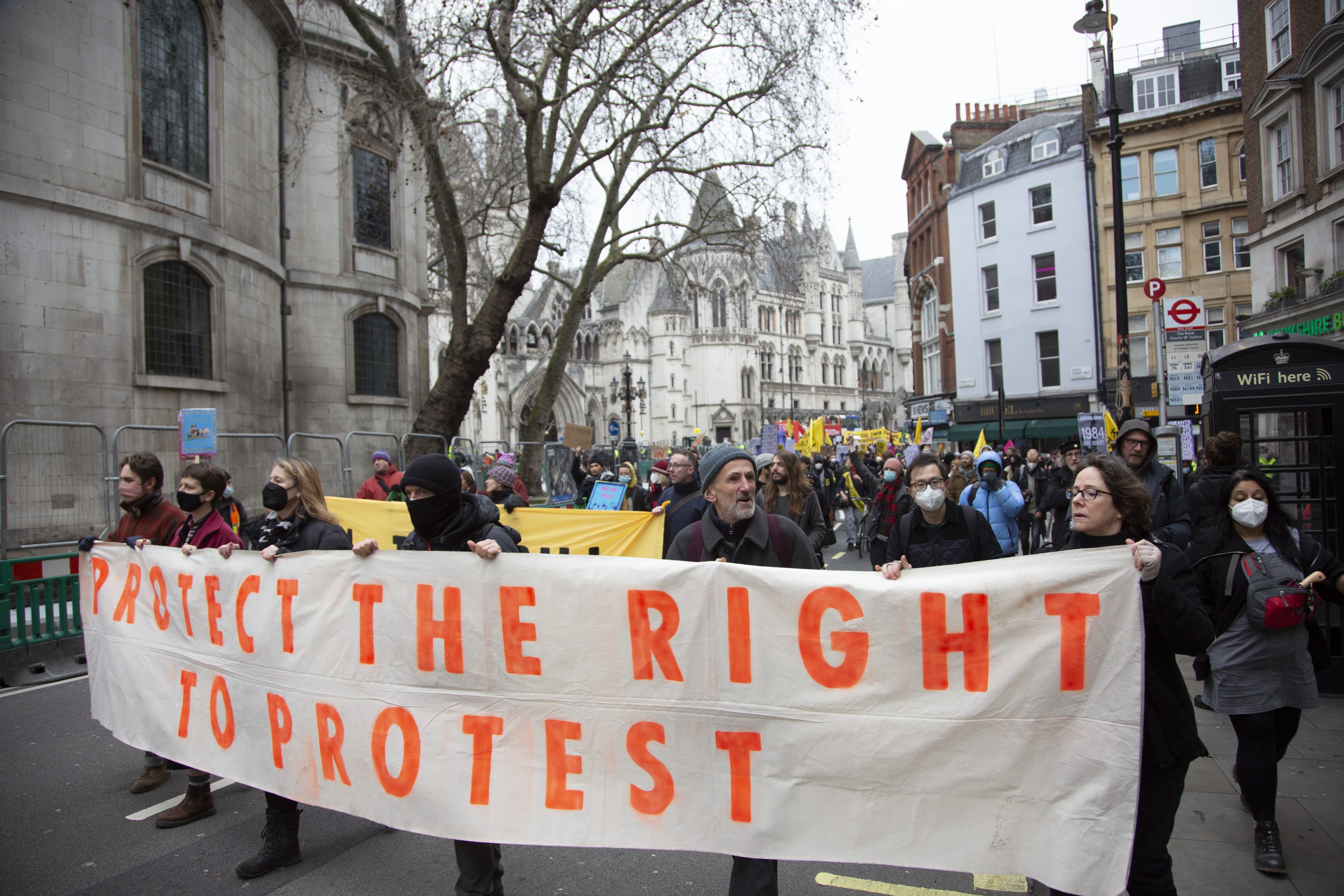 Demonstrators hold a banner that reads "Protect the right to protest"