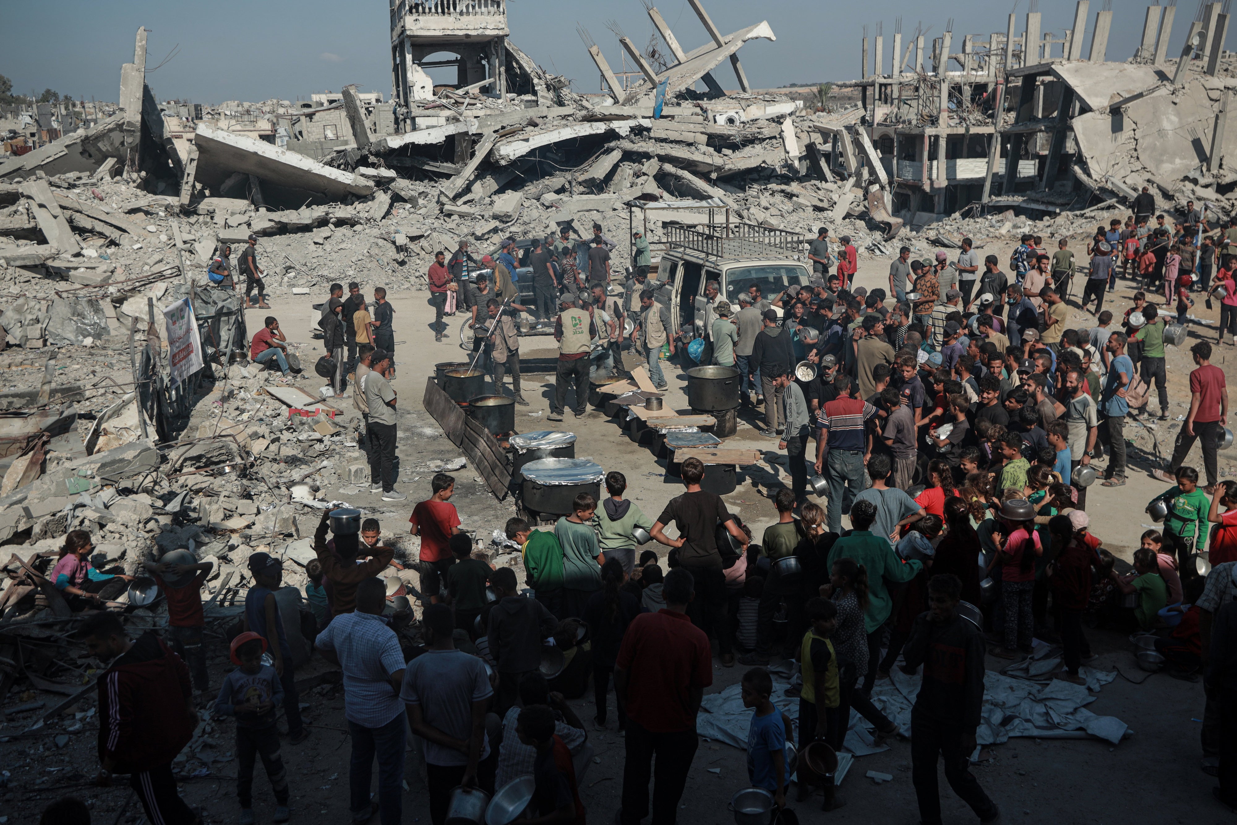 Des Palestiniens se pressent sur un site où une organisation caritative distribue de la nourriture chaude, alors que persiste une grave pénurie alimentaire, à Beit Lahia, dans la bande de Gaza, le 28 octobre 2025. 