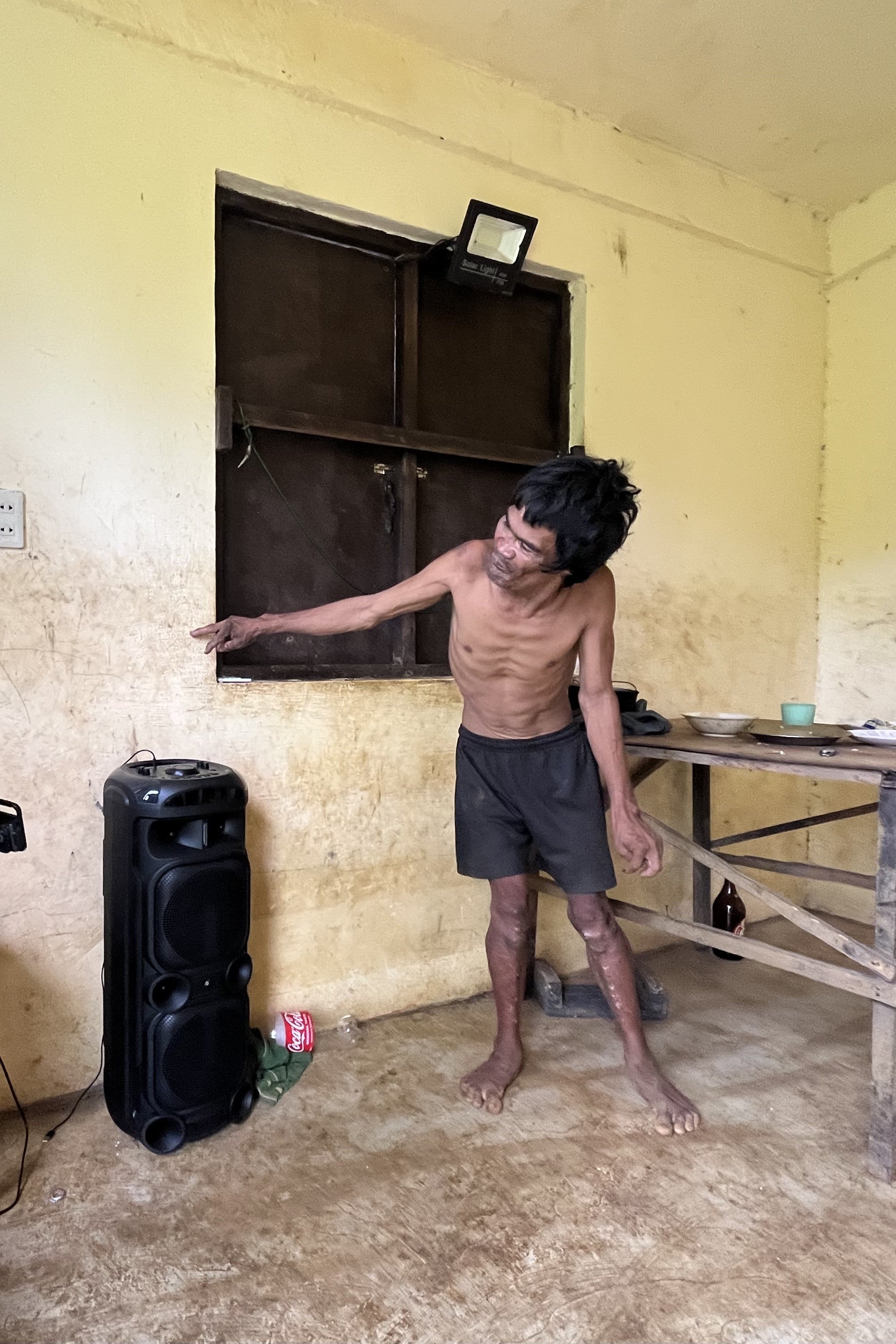 A man points to a spot on a wall