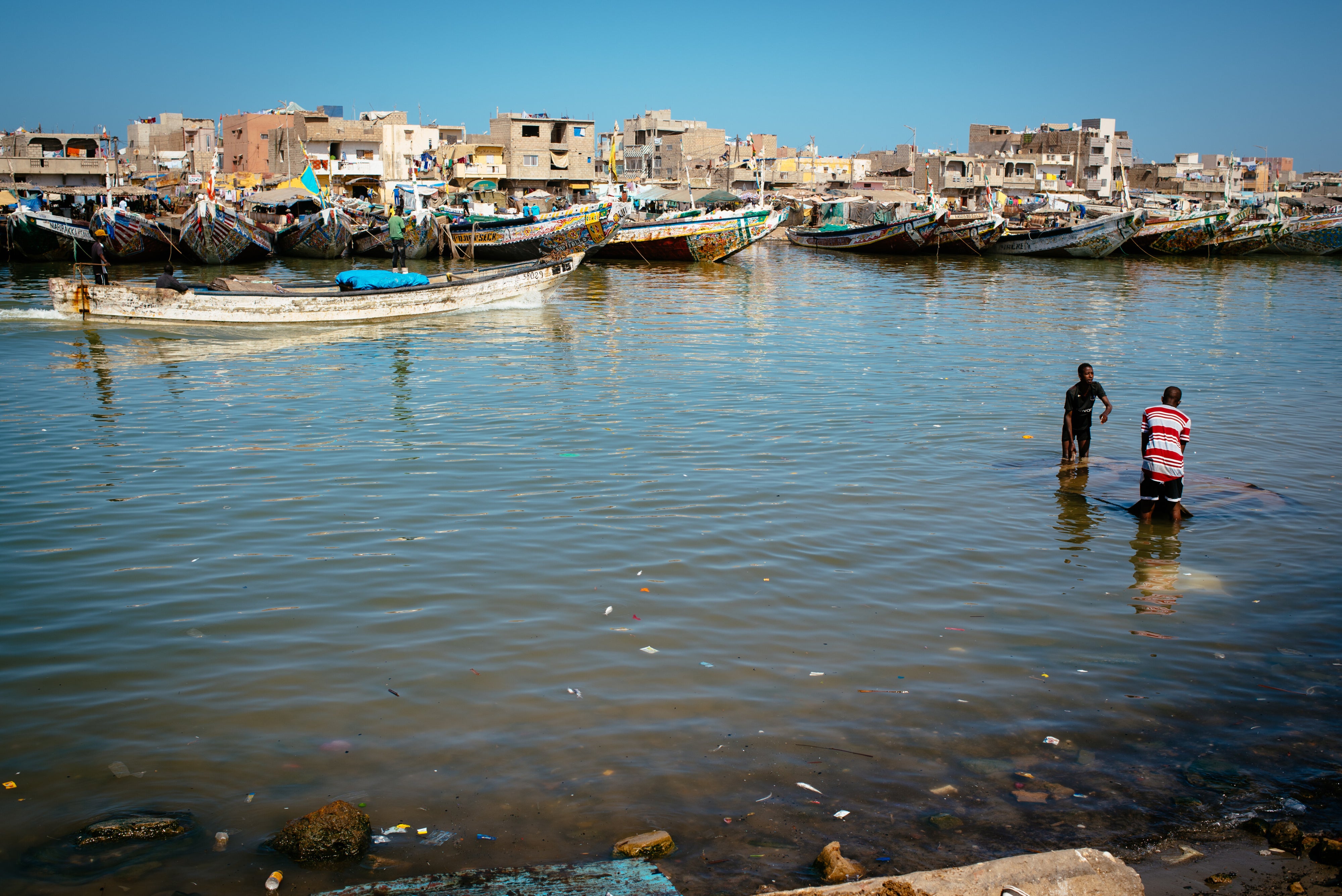 Two people working on a sunken boat  in the Langue de Barbarie, Saint-Louis, Senegal, March 7, 2023. 