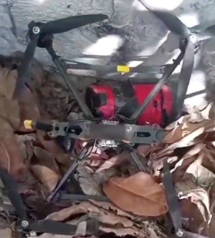 Capture d’écran d’une vidéo mise en ligne sur le réseau social X le 28 novembre 2025, montrant un drone quadricoptère au sol et ce qui semble être une munition imprimée en 3D non explosée.