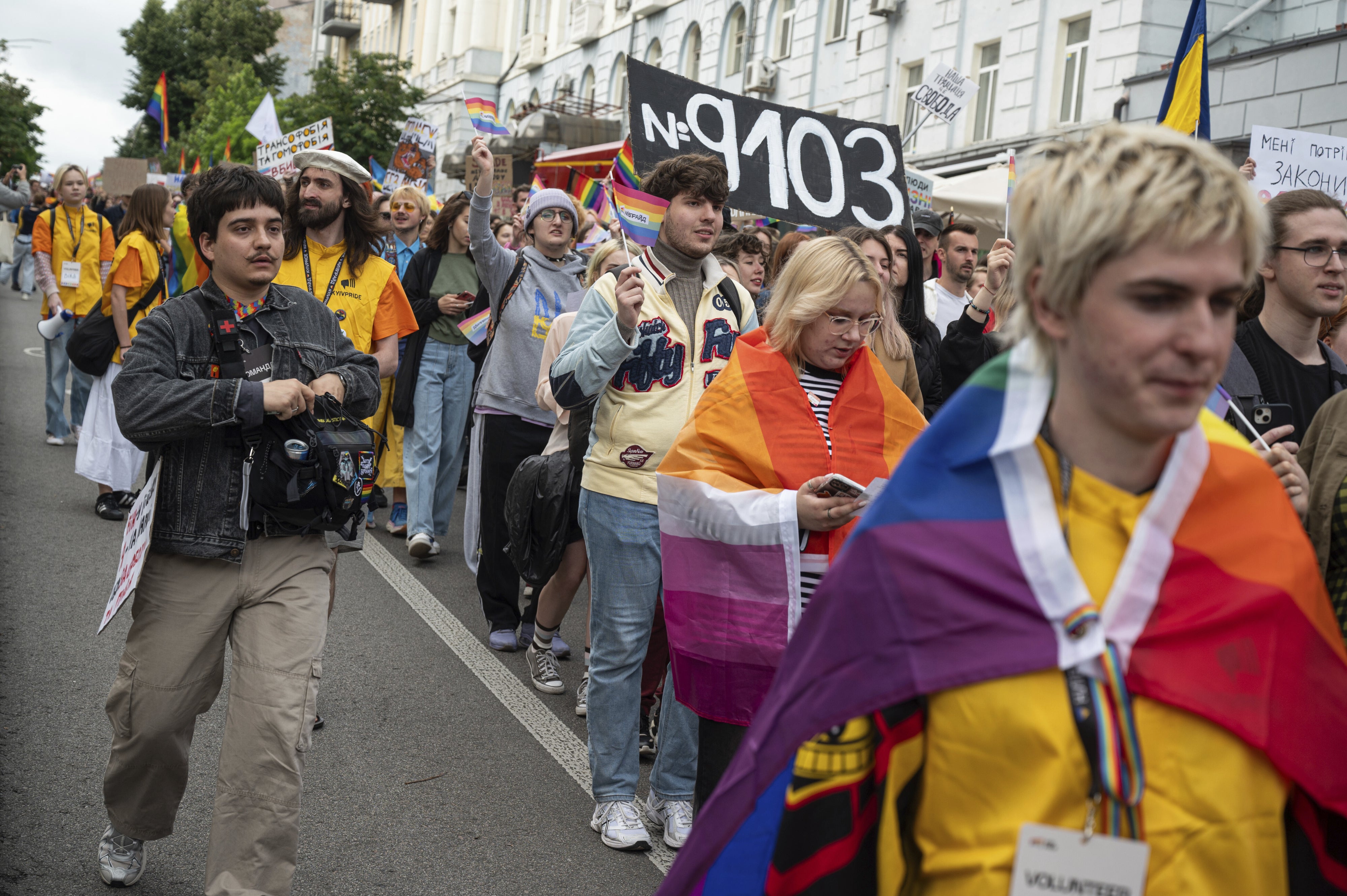 Des participants à la Marche pour l'égalité de la Kyiv Pride 2025 brandissent une pancarte en faveur du projet de loi n° 9103, qui propose la reconnaissance légale des partenariats civils en Ukraine, le 14 juin 2025.