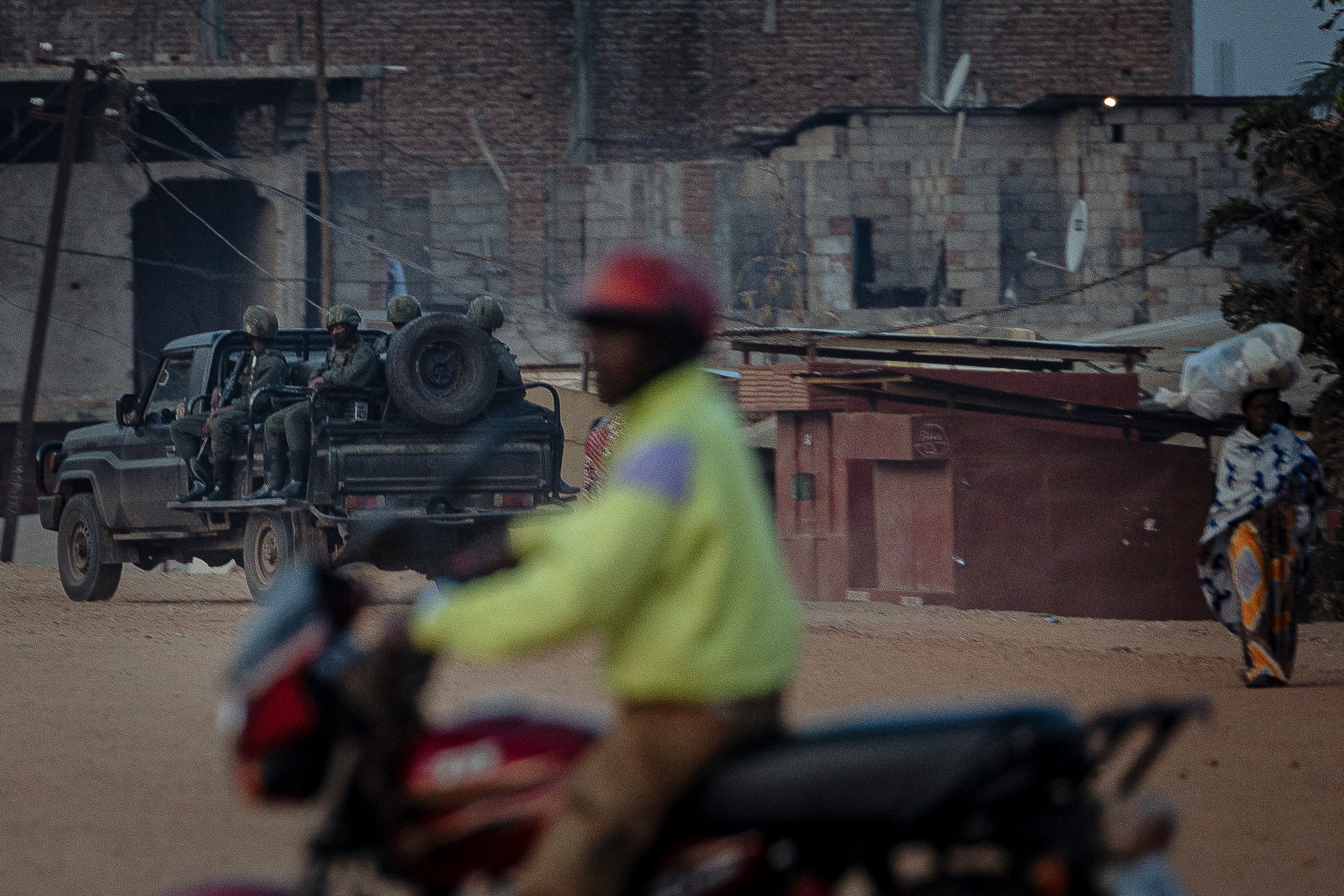 A car of armed soldiers patrols a street