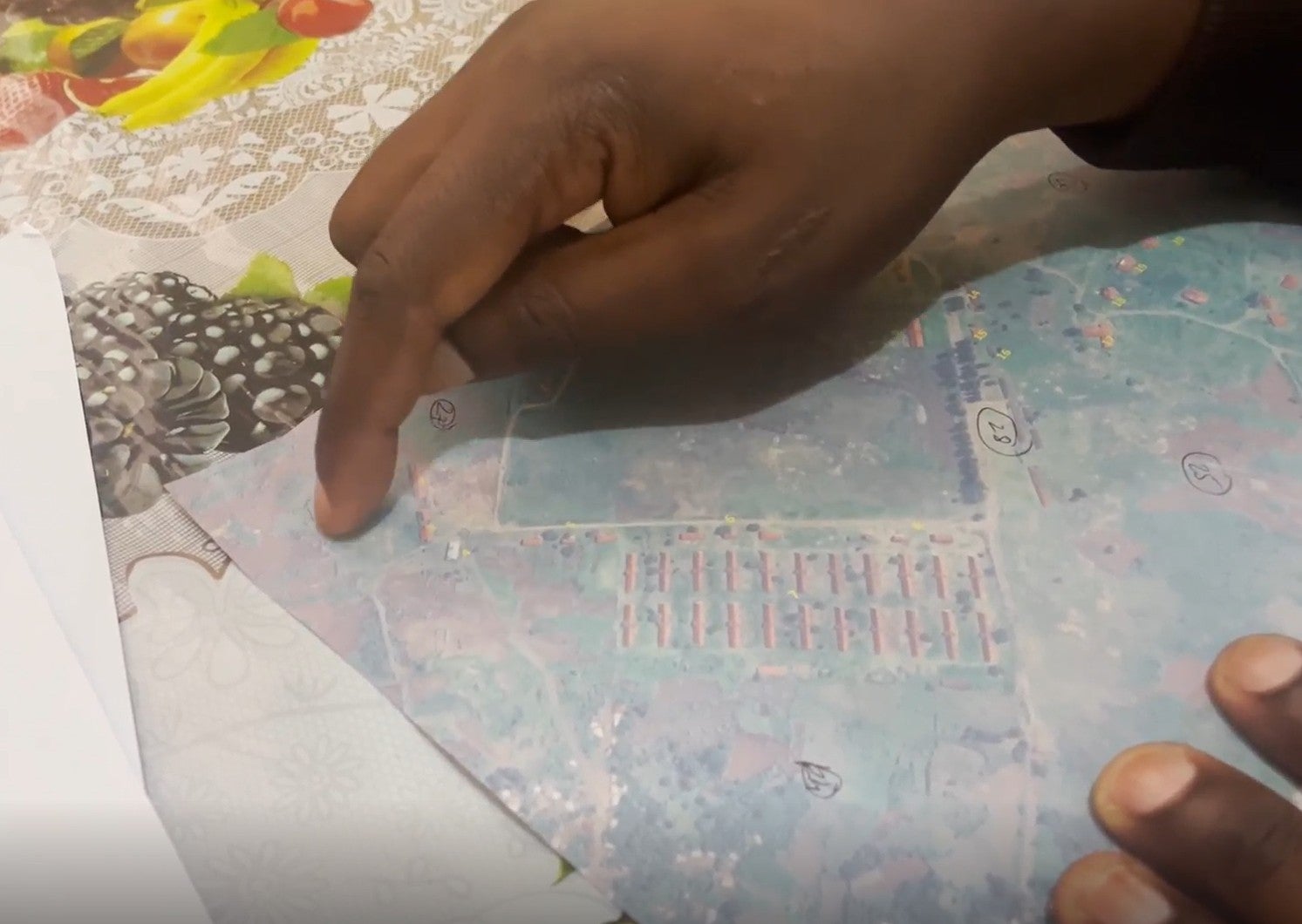 A person points at a printed satellite image