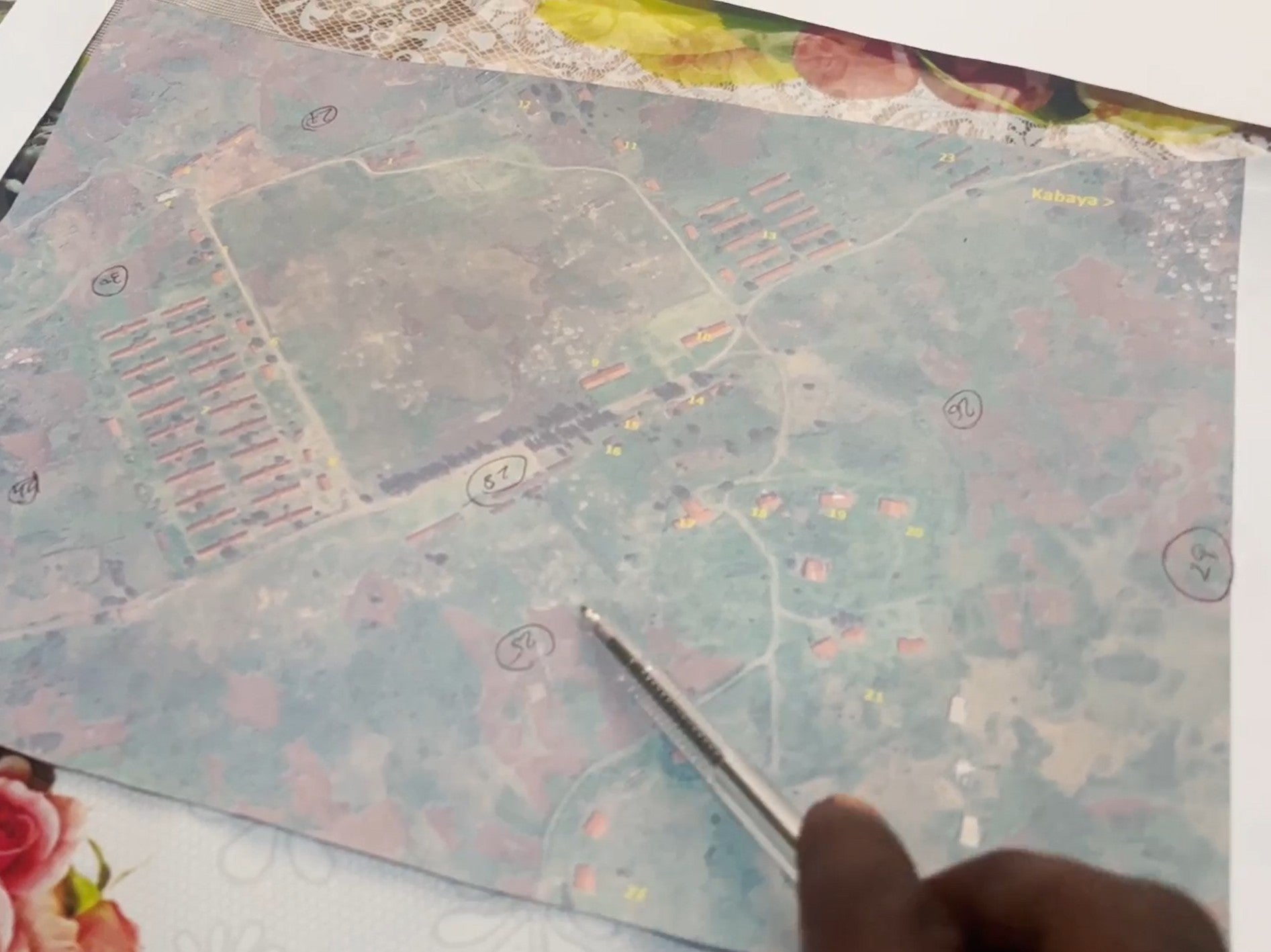 A person points at a printed satellite image