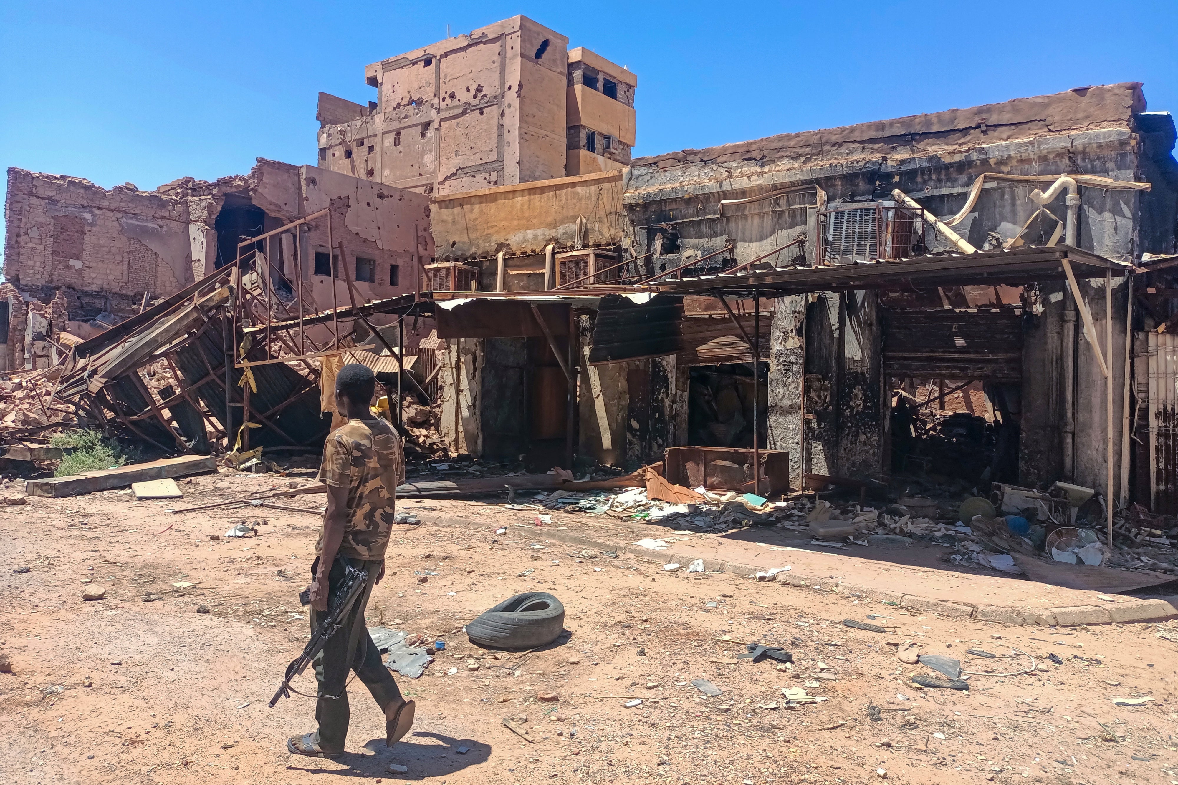 مقاتل موالٍ للجيش في دورية في محيط سوق في الخرطوم في 24 مارس/آذار 2025.