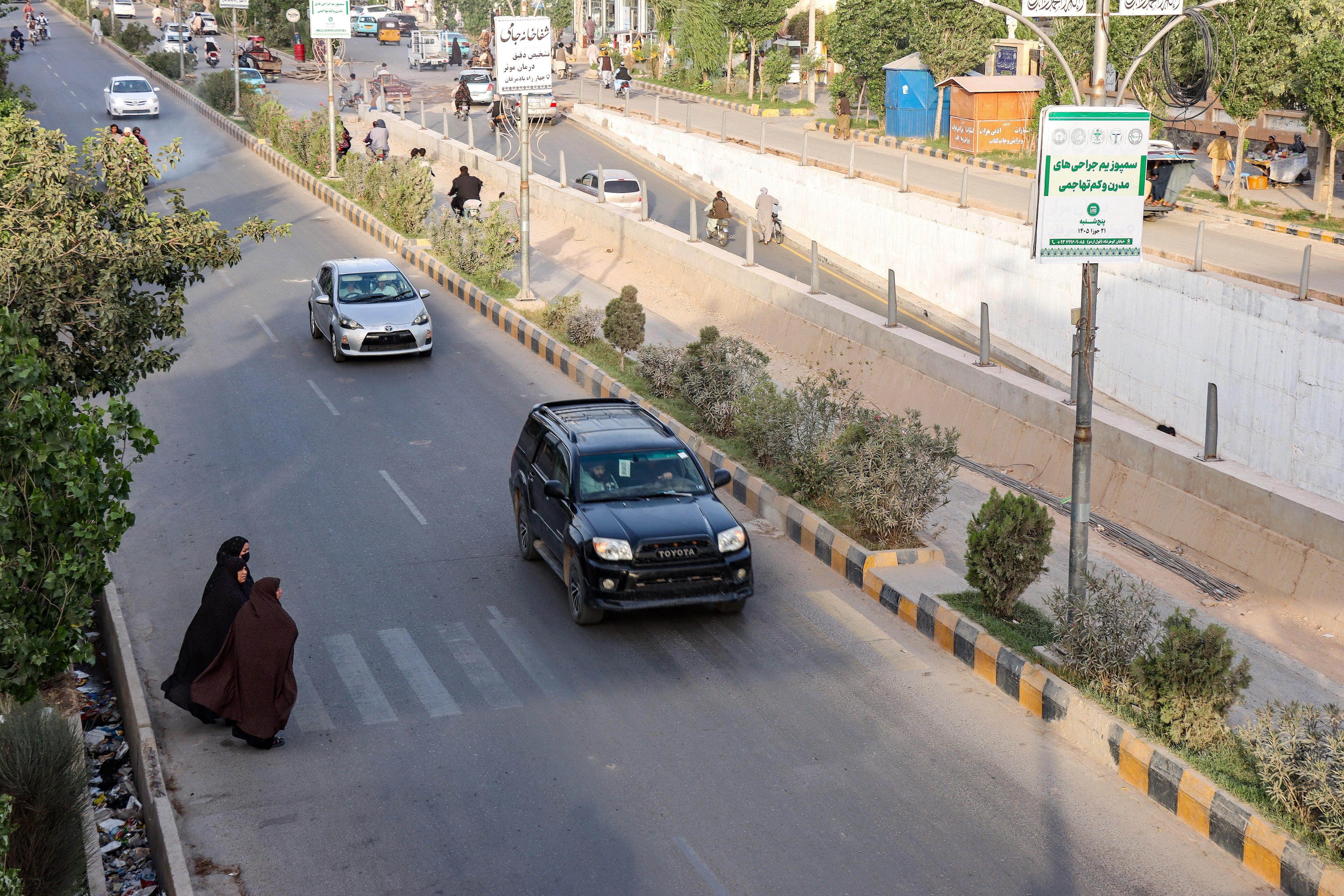 Afghan women walk across a street in Herat on June 8, 2026.