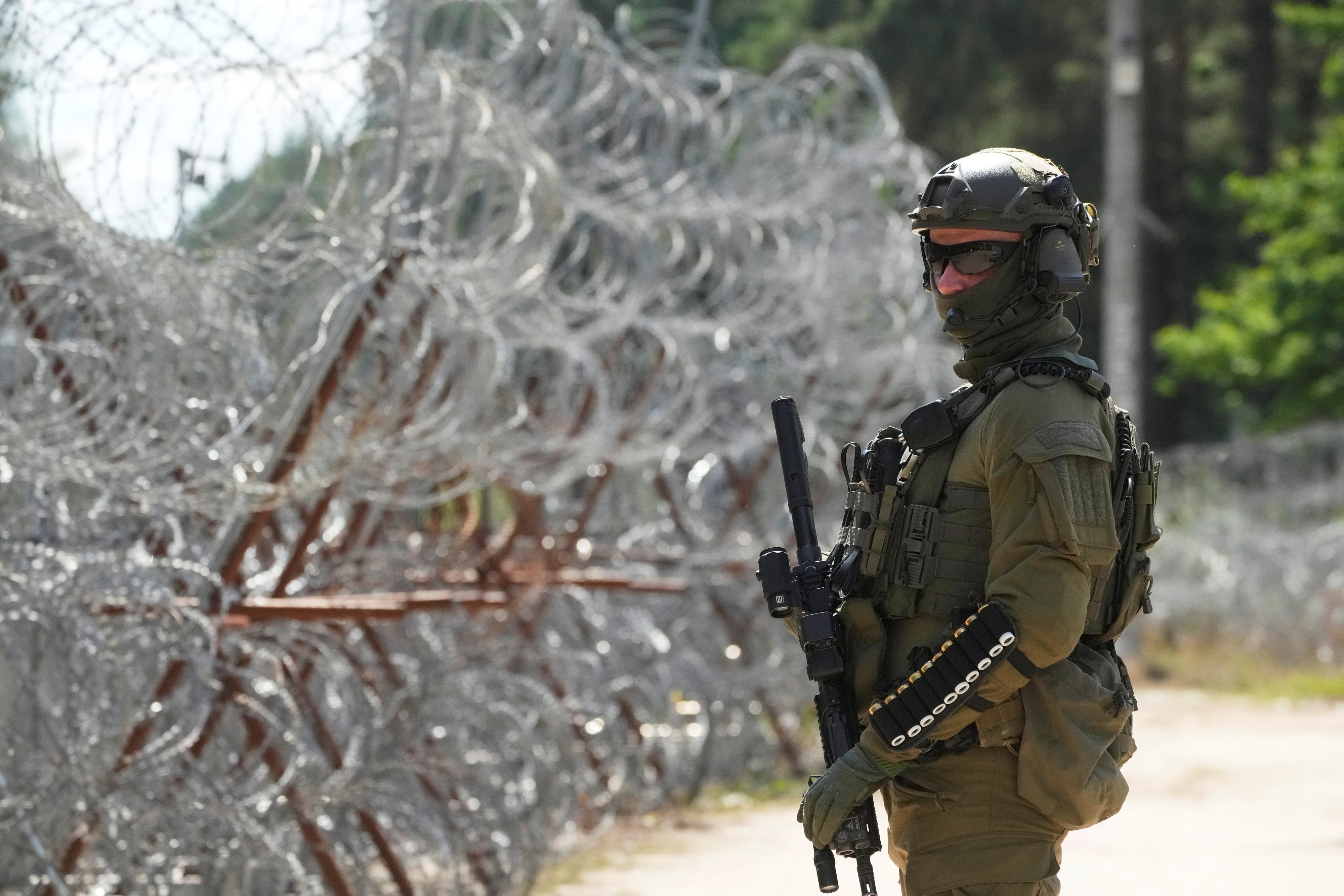 Ein polnischer Grenzschutzbeamter steht am Stacheldrahtzaun an der polnisch-belarussischen Grenze in Polowce, Polen, am 21. Juli 2025. © 2025 AP Photo/Czarek Sokolowski